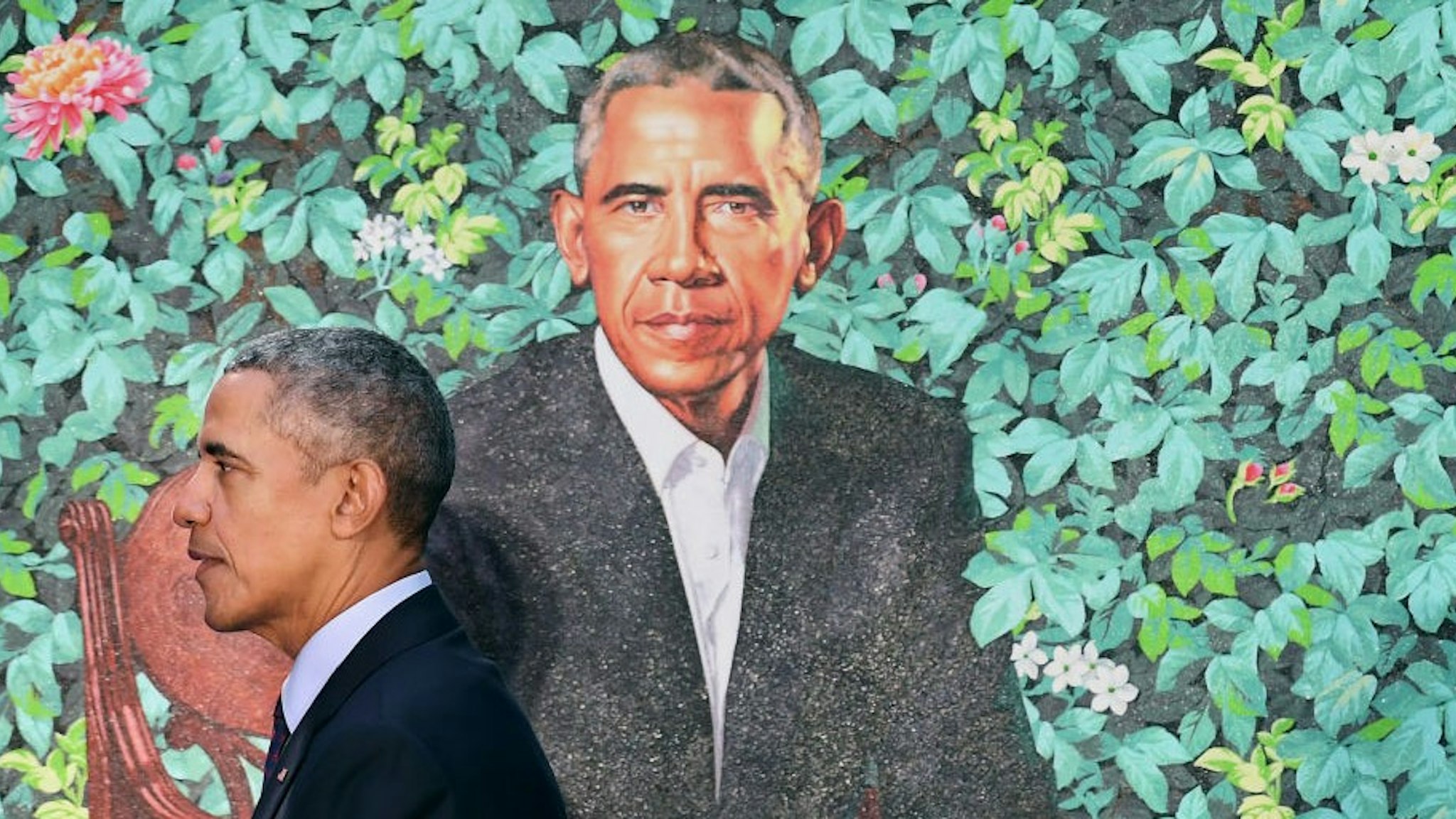 WASHINGTON, DC - FEBRUARY 12: Former President Barack Obama walks by his presidential portrait as he and former First Lady Michelle Obama have their portraits unveiled at the Smithsonian National Portrait Gallery on Monday February 12, 2018 in Washington, DC. The former President's portrait was painted by Kehinde Wiley while the former First Lady's portrait was painted by Amy Sherald. (Photo by Matt McClain/The Washington Post via Getty Images)