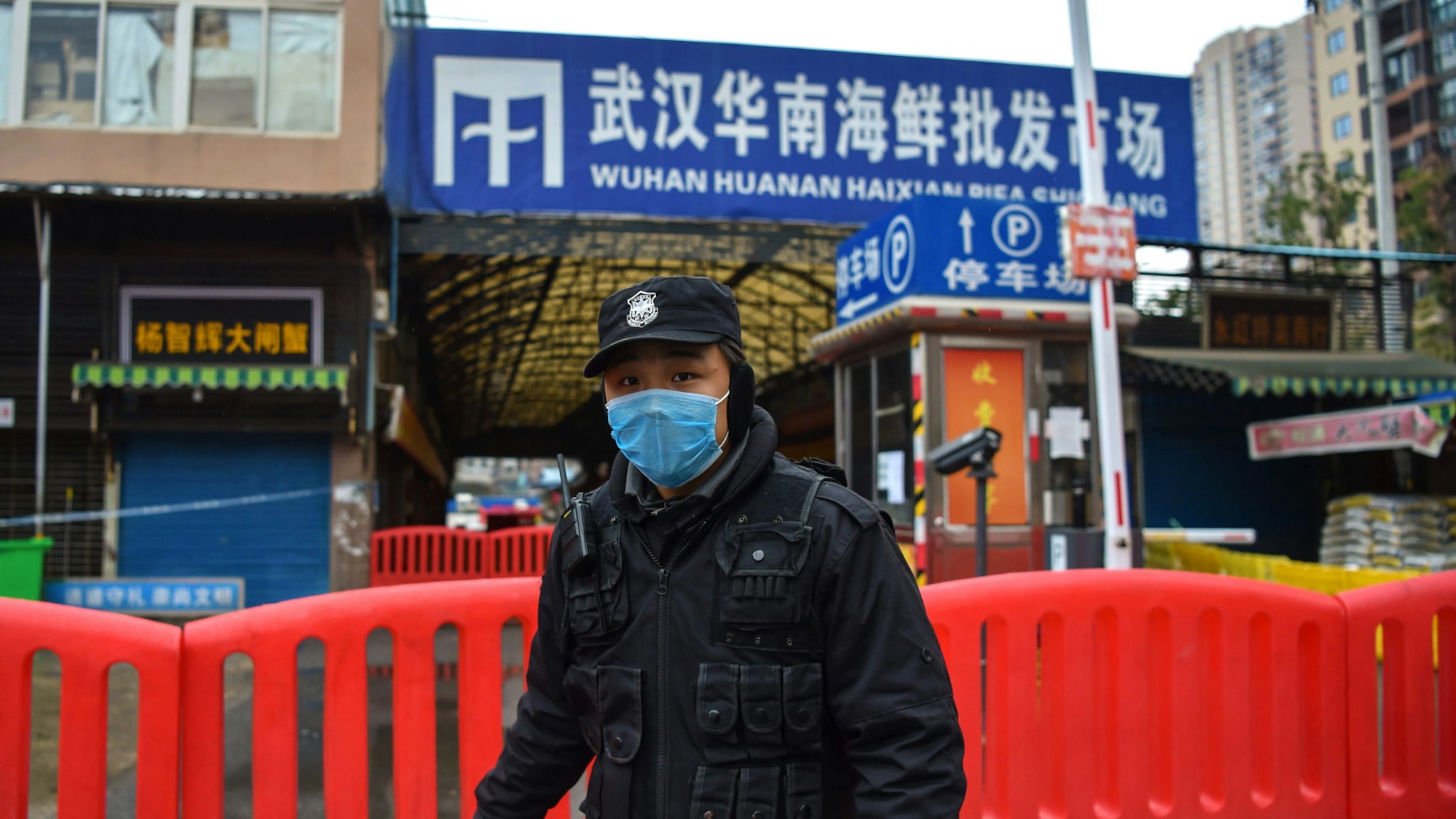 A police officer stands guard outside of Huanan Seafood Wholesale market where the coronavirus was detected in Wuhan on January 24, 2020. - The death toll in China's viral outbreak has risen to 25, with the number of confirmed cases also leaping to 830, the national health commission said.