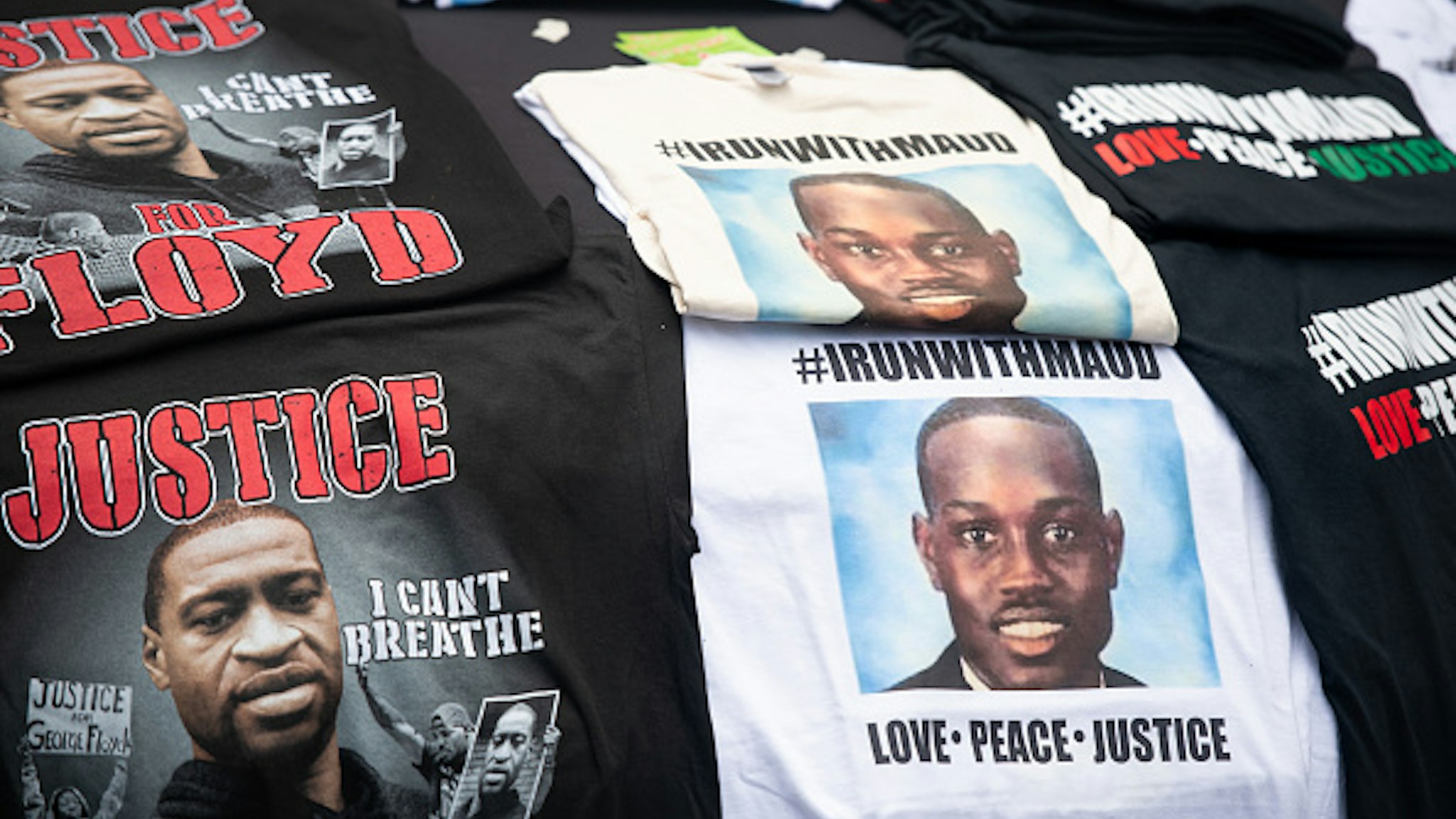 BRUNSWICK, GA - JUNE 04: T-shirts memorializing George Floyd and Ahmaud Arbery are displayed for sale on a car hood outside the Glynn County courthouse during a court appearance by Gregory and Travis McMichael, two suspects in the fatal shooting of Ahmaud Arbery, on June 4, 2020 in Brunswick, Georgia. Arbery was killed on February 23.