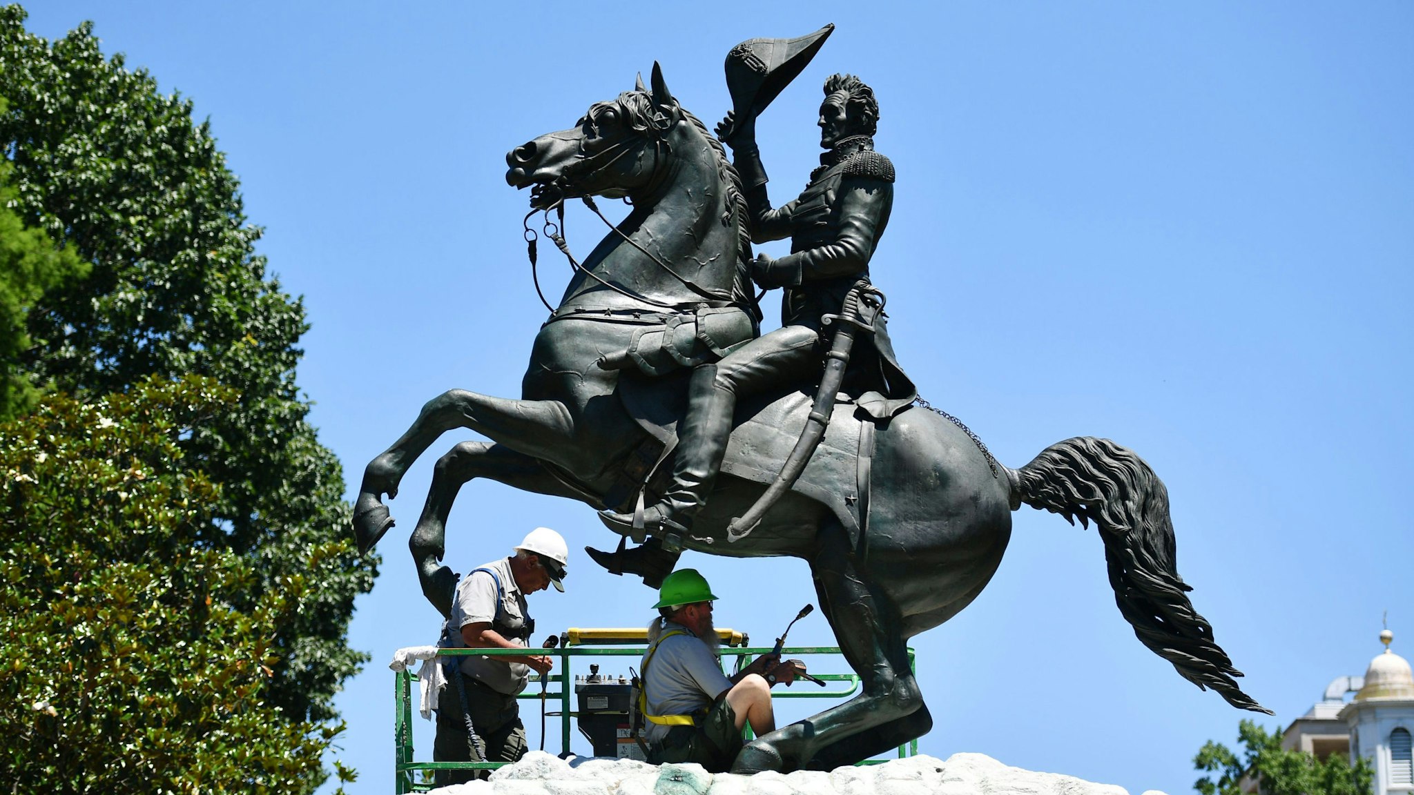 Workers clean a statue of Andrew Jackson in the recently reopened Lafayette Square near the White House, in Washington, DC on June 12, 2020.