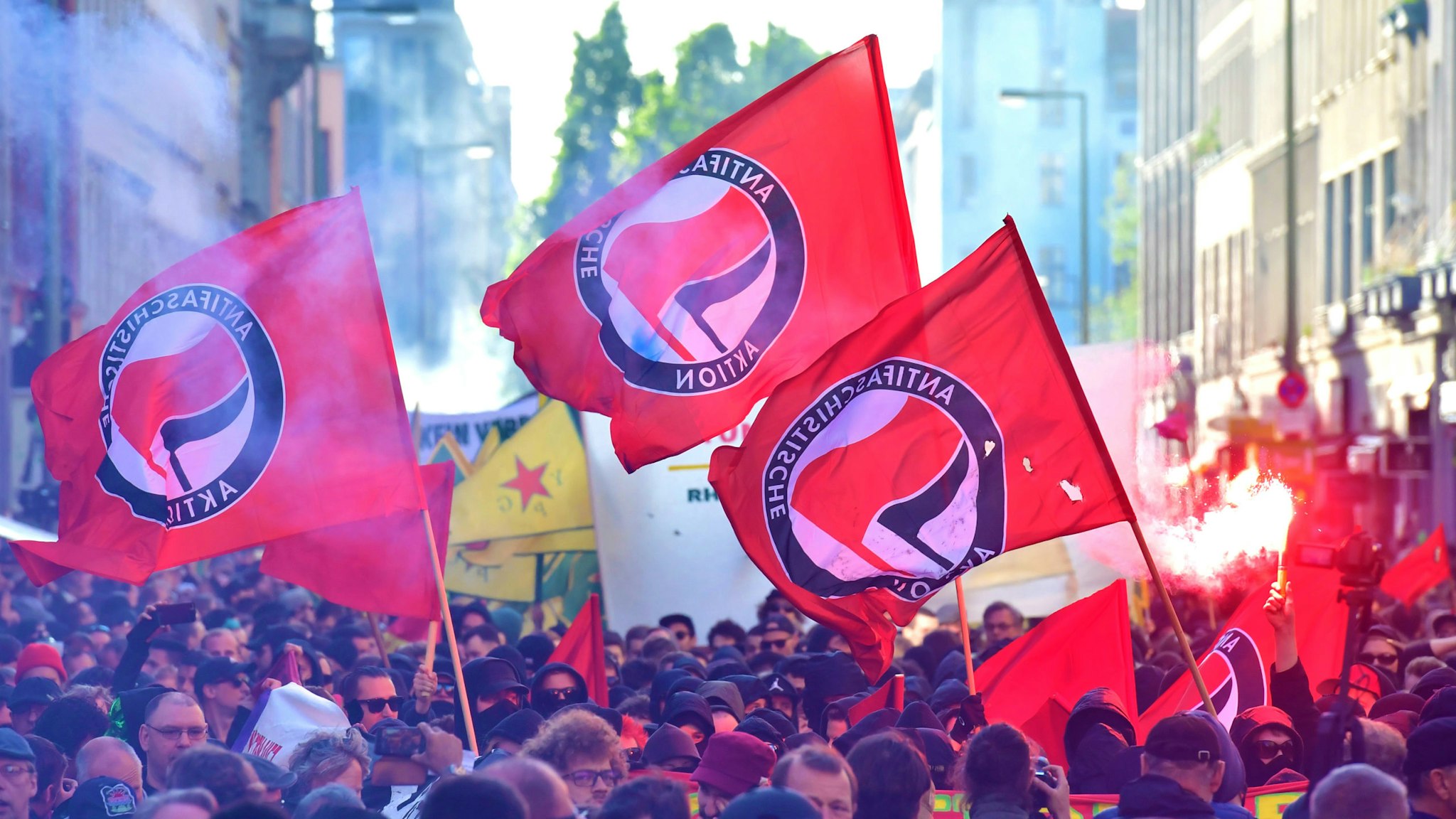 Participants of the "Revolutionary 1st of May Demonstration" light flares and wave flags of the left-wing, Anti-Fascist Antifa movement during May Day events on May 1, 2018 in Berlin.