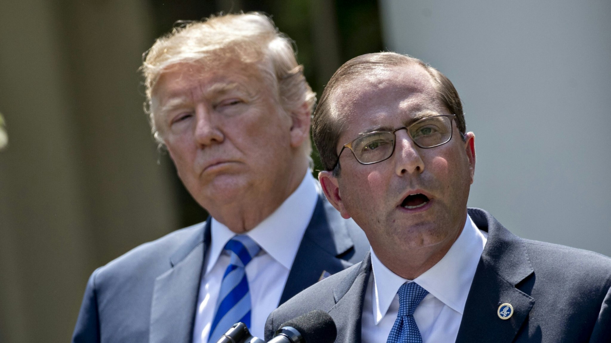 Alex Azar, secretary of Health and Human Services (HHS), right, speaks as U.S. President Donald Trump listens during an event on lowering drug prices in the Rose Garden of the White House in Washington, D.C., U.S., on Friday, May 11, 2018.
