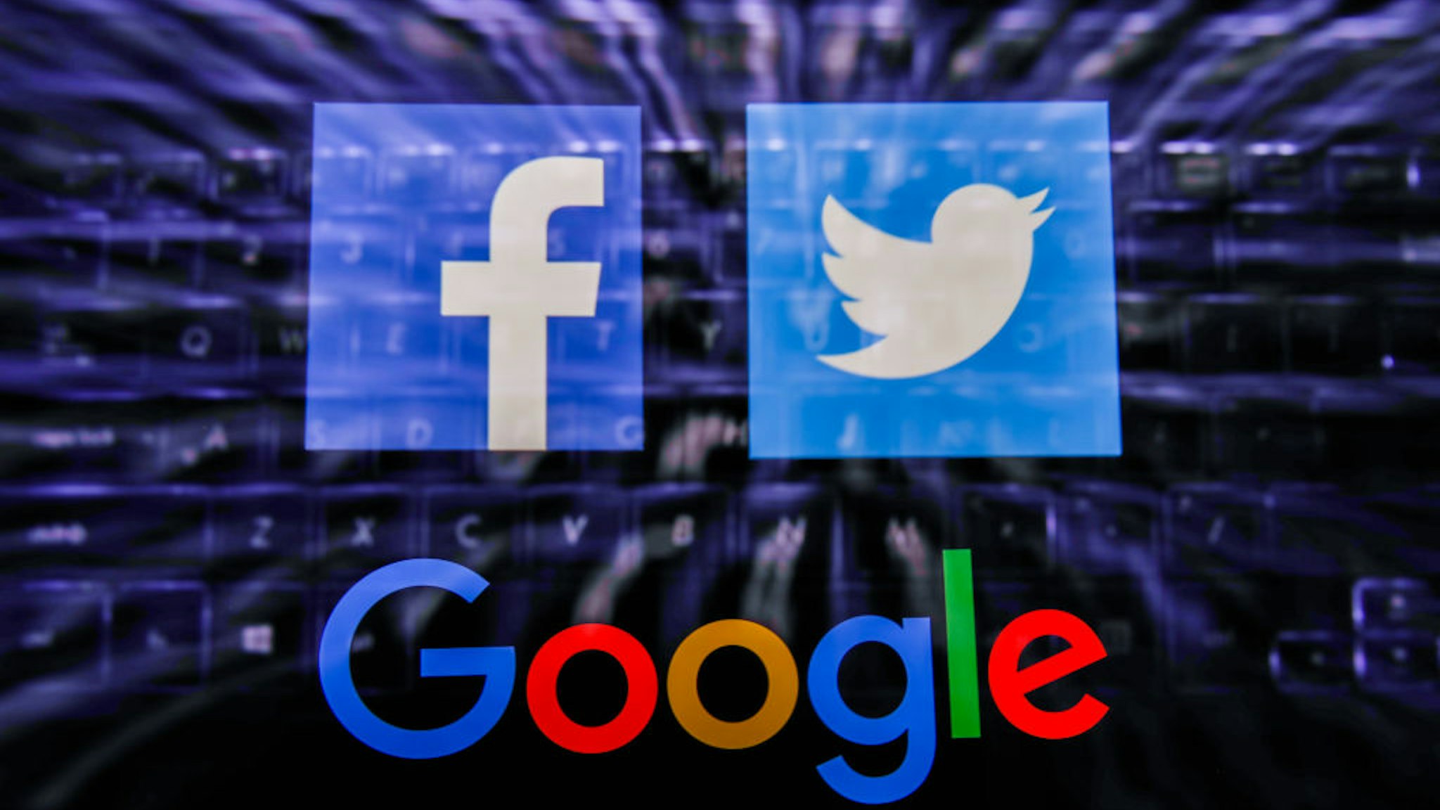 Facebook, Twitter and Google logos displayed on a phone screen and keyboard are seen in this multiple exposure illustration photo taken in Poland on June 14, 2020. European Commission officials said that Facebook, Twitter and Google should provide monthly fake news reports to prevent fake news about coronavirus pandemic. (Photo Illustration by Jakub Porzycki/NurPhoto via Getty Images)