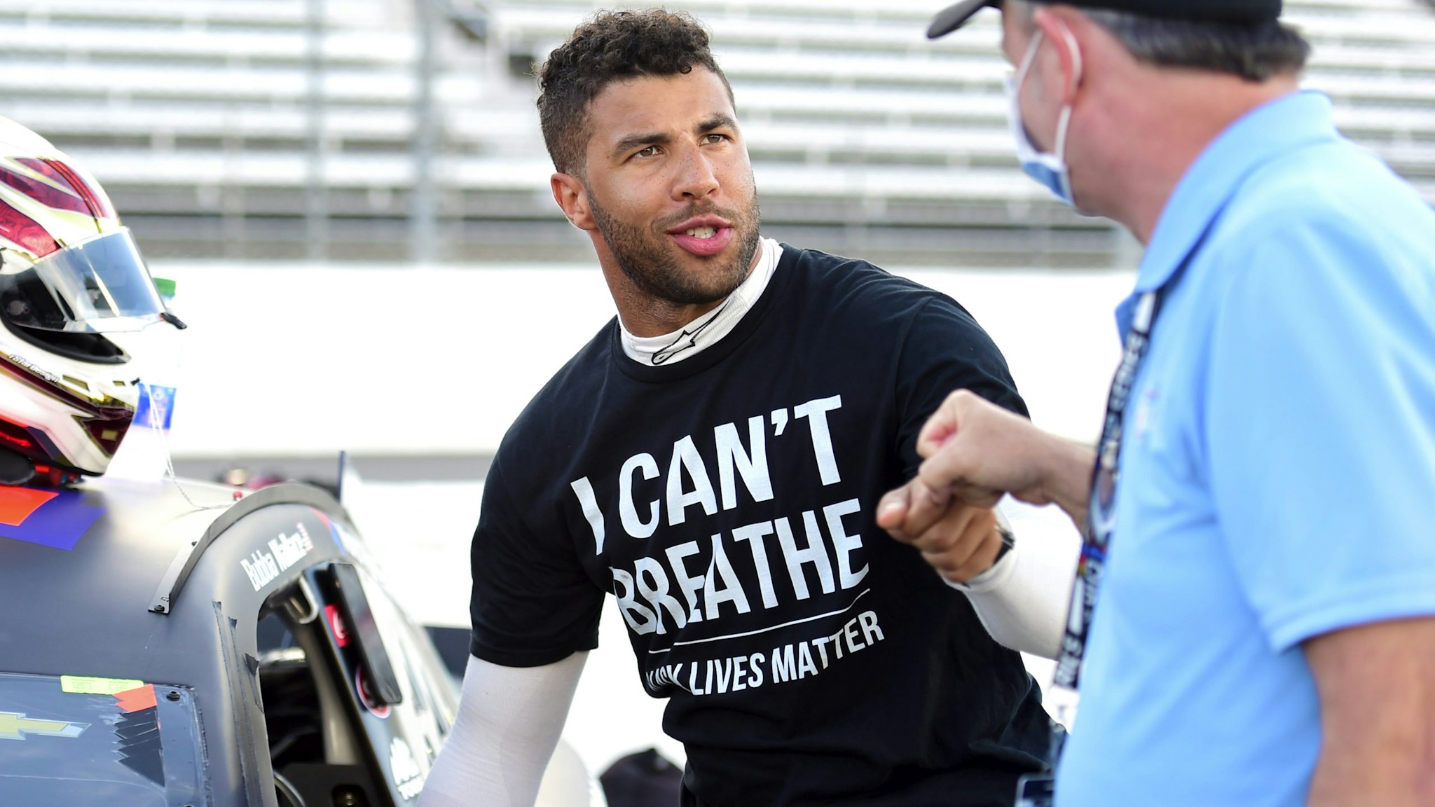 MARTINSVILLE, VIRGINIA - JUNE 10: Bubba Wallace, driver of the #43 Richard Petty Motorsports Chevrolet, wears a "I Can't Breathe - Black Lives Matter" t-shirt under his fire suit in solidarity with protesters around the world taking to the streets after the death of George Floyd on May 25, and crew bump fist prior to the NASCAR Cup Series Blue-Emu Maximum Pain Relief 500 at Martinsville Speedway on June 10, 2020 in Martinsville, Virginia.