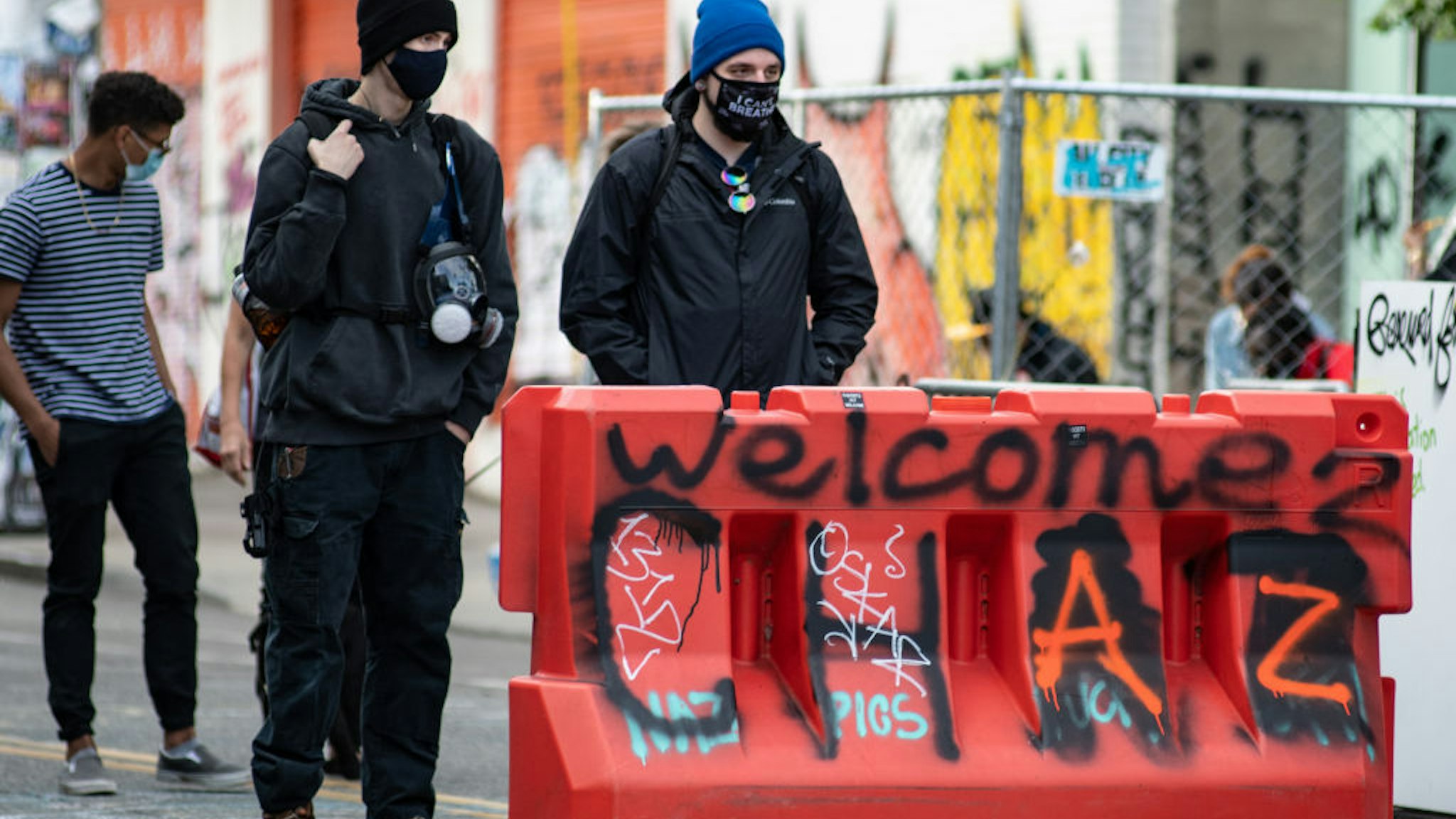 Two people stand at an entrance to the √¢Capitol Hill Organized Protest√¢ formerly known as the √¢Capitol Hill Autonomous Zone√¢ in Seattle, Washington on June 14, 2020. The √¢Capitol Hill Organized Protest√¢ was formed after Seattle Police abandoned its East Precinct during protests against police brutality and the death of George Floyd, an unarmed black man who died after being pinned down by a white police officer in Minneapolis, Minnesota, United States on May 25, 2020. (Photo by Noah Riffe/Anadolu Agency via Getty Images)