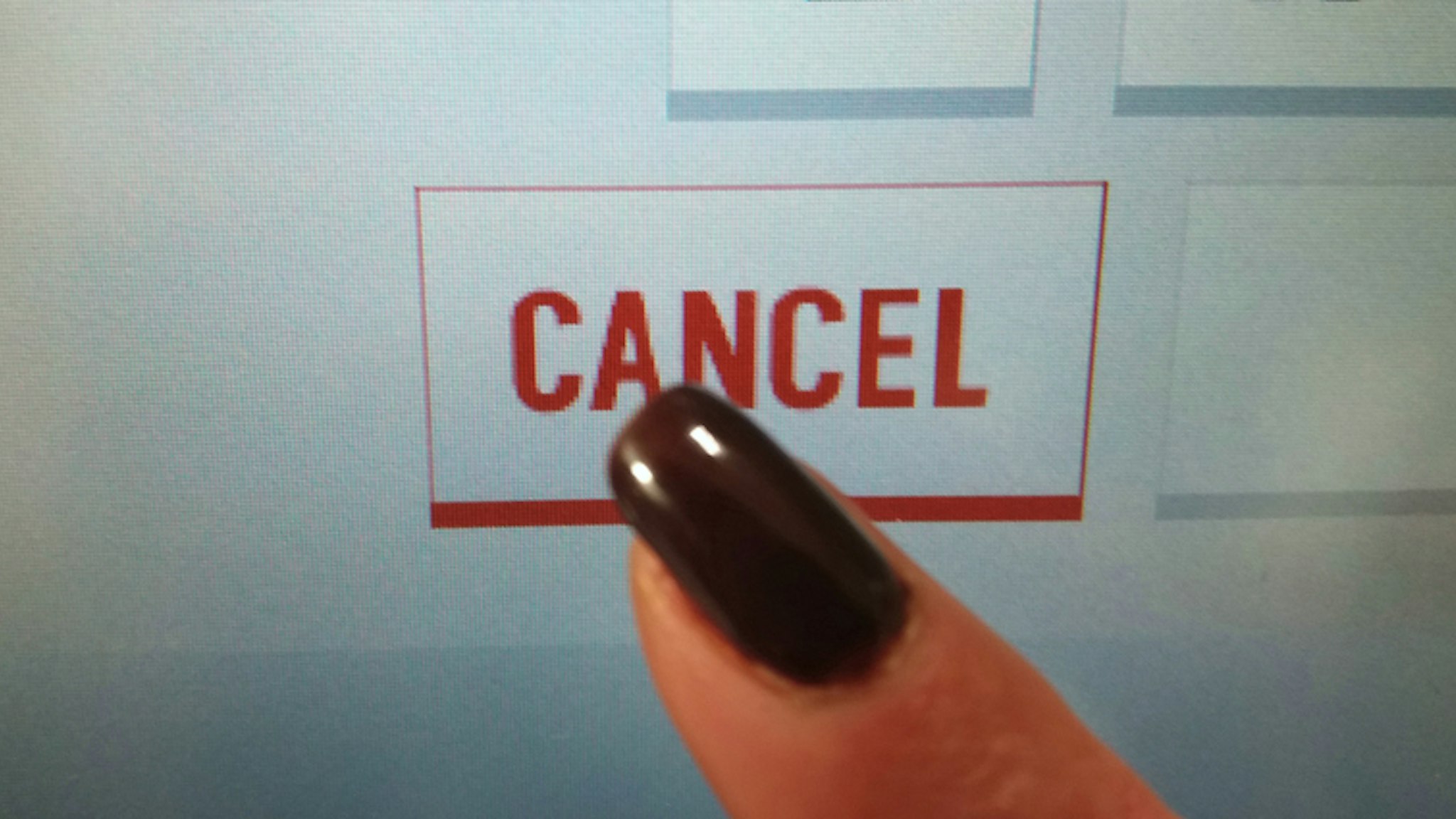 Finger clicks the word CANCEL on the touch screen