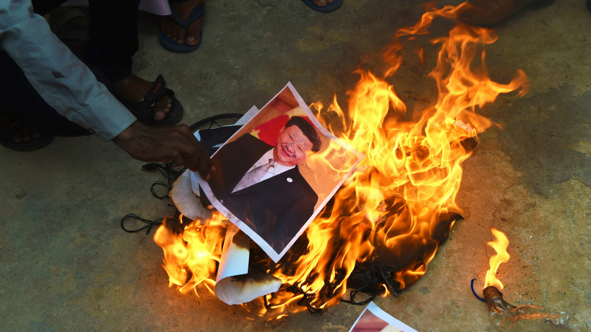 Members of the non-governmental organisation MADADGAAR PARIVAR, burn a poster of Chinese President Xi Jinping along with Chinese items as they protest against the killing of the three Indian soldiers by Chinese troops, in Ahmedabad on June 16, 2020. - Three Indian soldiers were killed in a violent face-off on the Chinese border, the Indian army said June 16, following weeks of rising tensions and the deployment of thousands of extra troops from both sides.