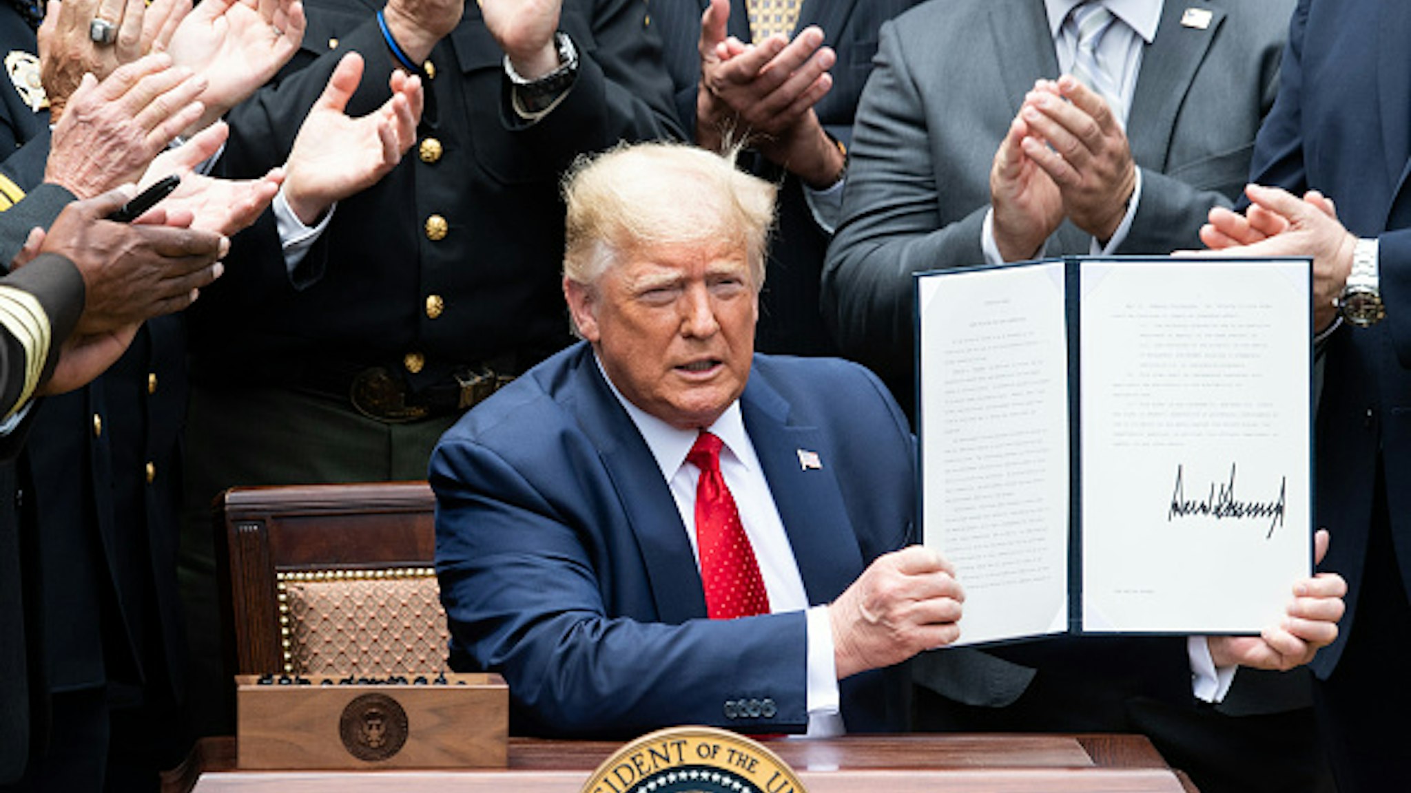 US President Donald Trump shows his signature on an Executive Order on Safe Policing for Safe Communities, in the Rose Garden of the White House in Washington, DC, June 16, 2020.