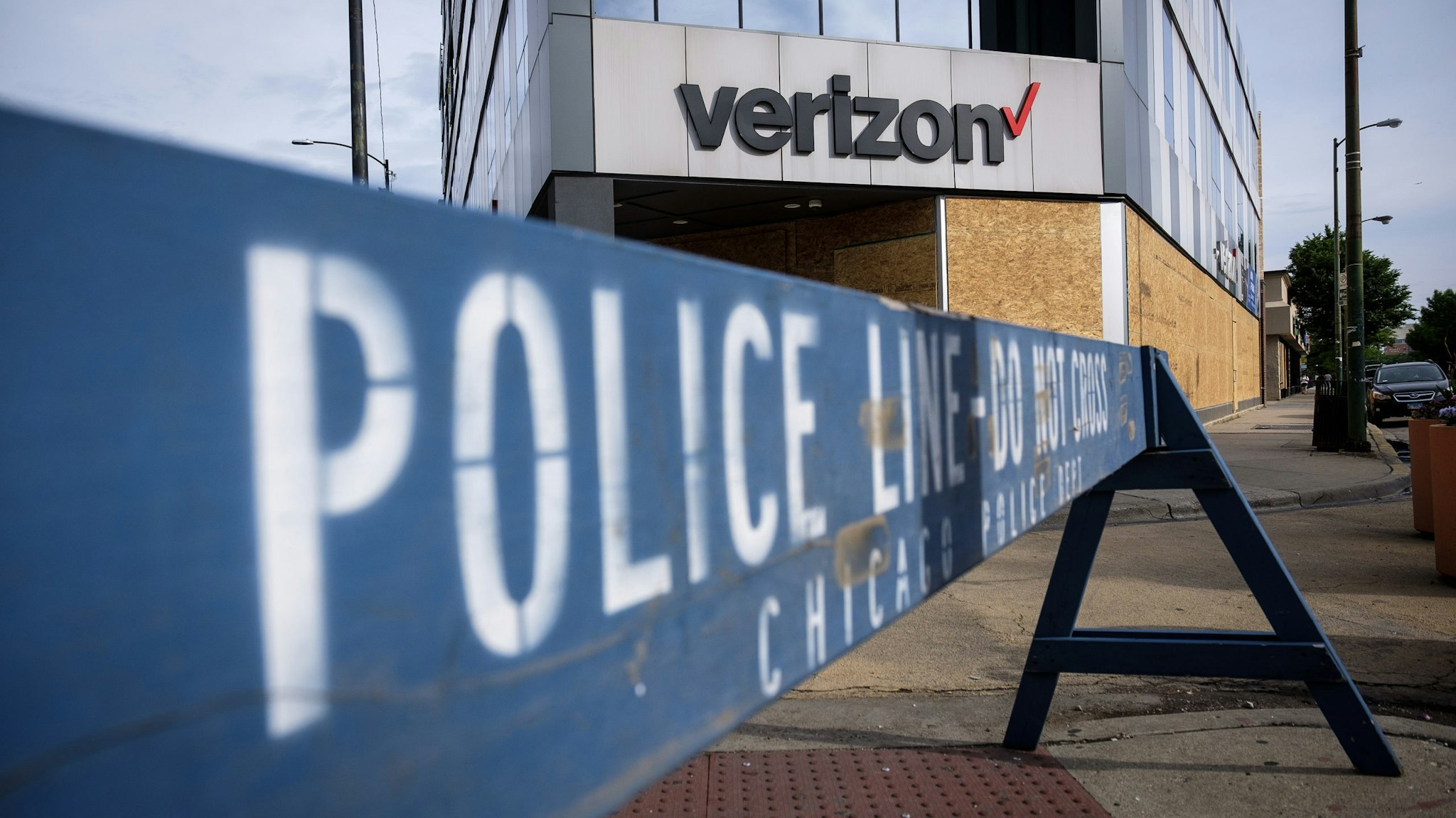 A police barricade stands in front of a boarded up Verizon store in Chicago, Illinois, U.S., on Friday, June 5, 2020. Protesters have come out in droves across the U.S. to speak out against the killing of George Floyd and though they have been largely peaceful, some people have used the unrest as an opportunity to vandalize and loot stores in many cities. Photographer: Christopher Dilts/Bloomberg via Getty Images