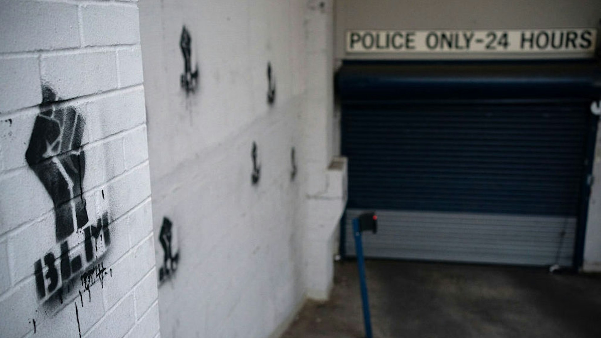 Black Lives Matter graffiti is painted at entrance to the Seattle Police Department's East Precinct, which has been boarded up and protected by fencing as demonstrators hold a rally and teach-in nearby on June 8, 2020 in Seattle, Washington.