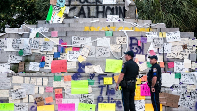 Charleston police officers stand in front of the vandalized John C. Calhoun Monument in Marion Square on June 17, 2020 in Charleston, South Carolina.
