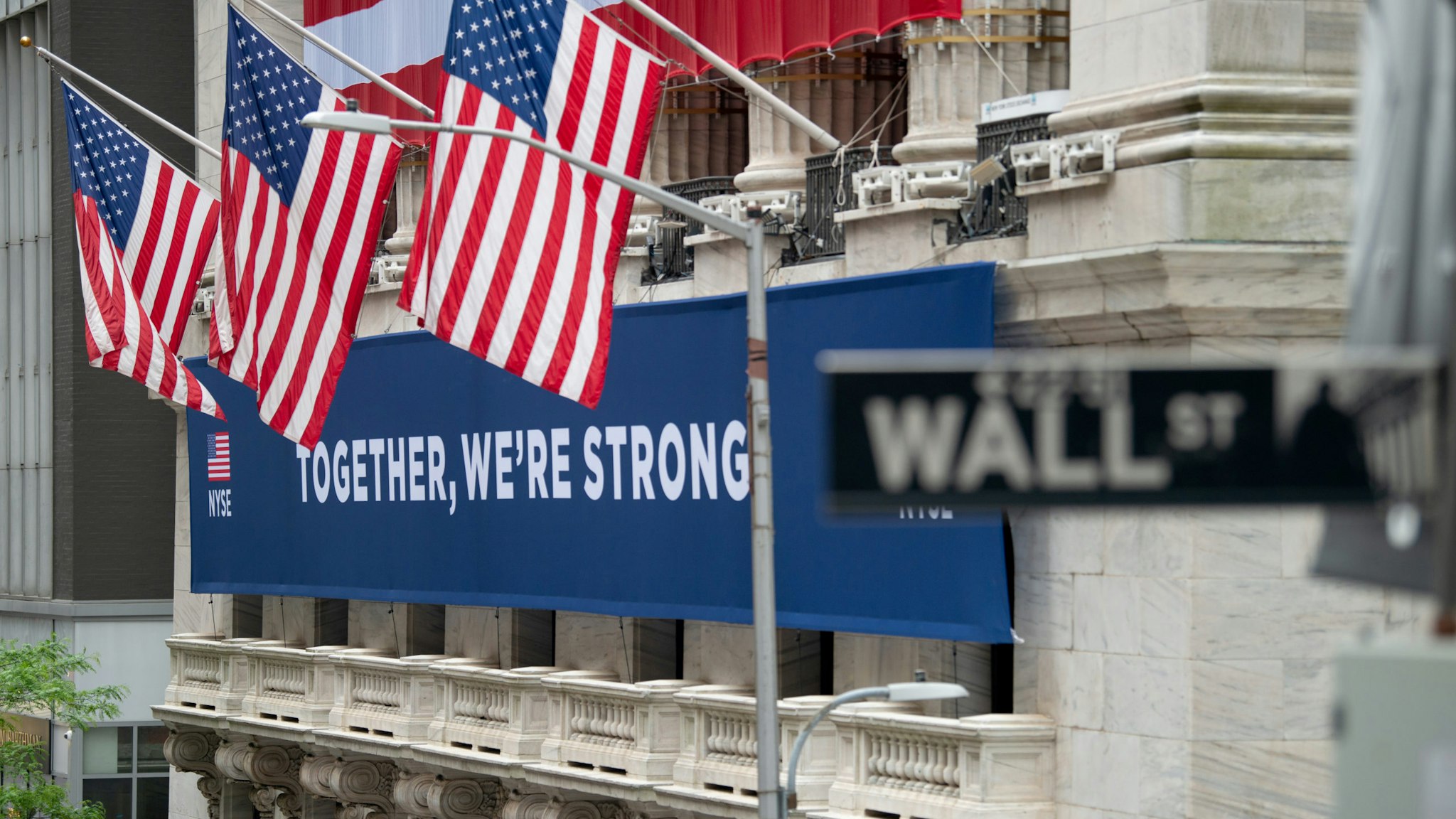 NEW YORK, NEW YORK - MAY 28: A view of the "Together, We're Strong" banner in front of the New York Stock Exchange on May 28, 2020 in New York City. The NYSE partially reopened its trading floor on May 25th after a two-month closure due to the COVID-19 pandemic. Government guidelines encourage wearing a mask in public with strong social distancing in effect as all 50 states in the USA have begun a gradual process to slowly reopen after weeks of stay-at-home measures to slow the spread of COVID-19. (Photo by Alexi Rosenfeld/Getty Images)