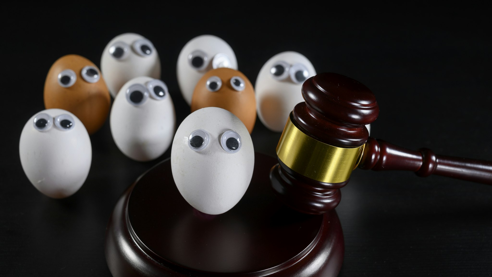 A white egg face is been judge. There are also brown eggs faces within the public. Anti-racism concept. - stock photo