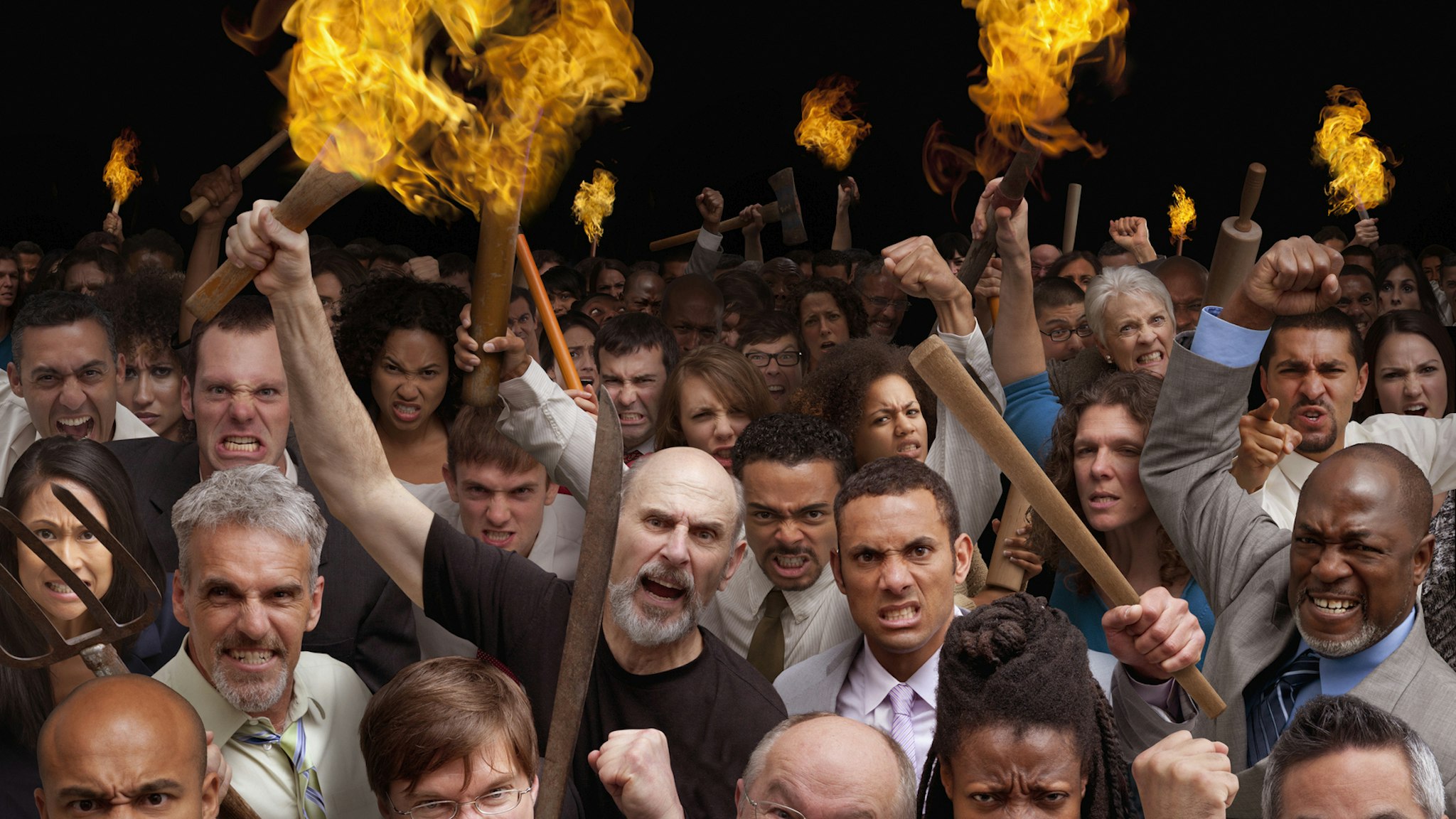 Angry crowd carrying torches - stock photo