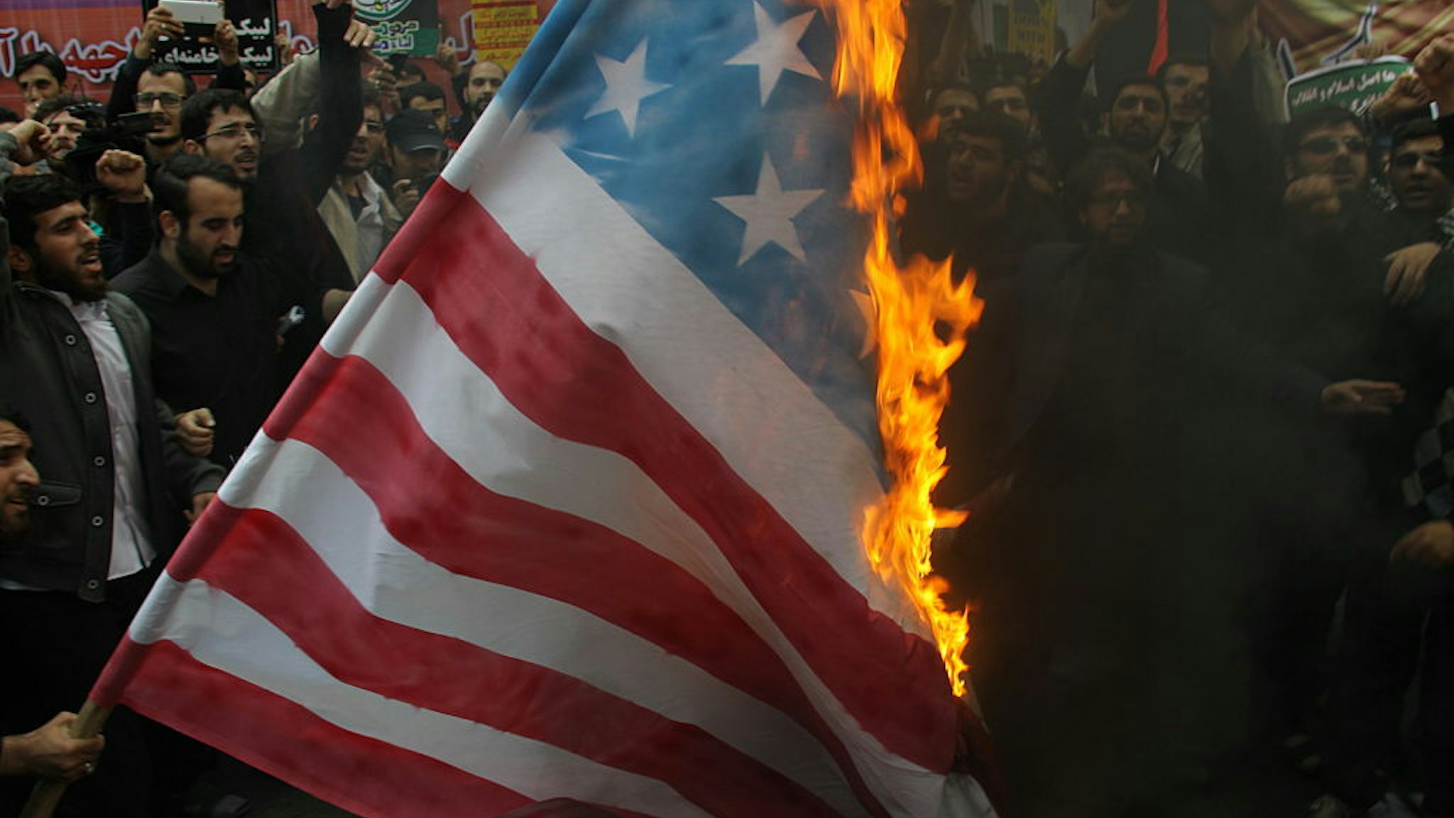 Iranians burn a US flag outside the former US embassy in the Iranian capital Tehran on November 4, 2015, during a demonstration marking the anniversary of its storming by student protesters that triggered a hostage crisis in 1979. Thousands of