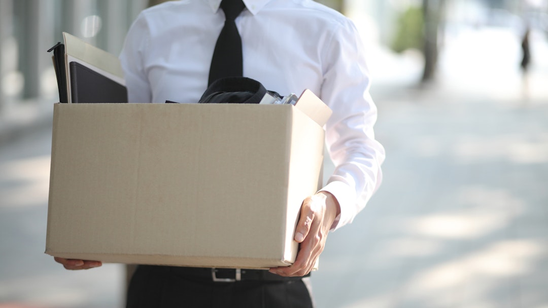 Close-up Of Unemployed Businessperson Carrying Cardboard Box - stock photo