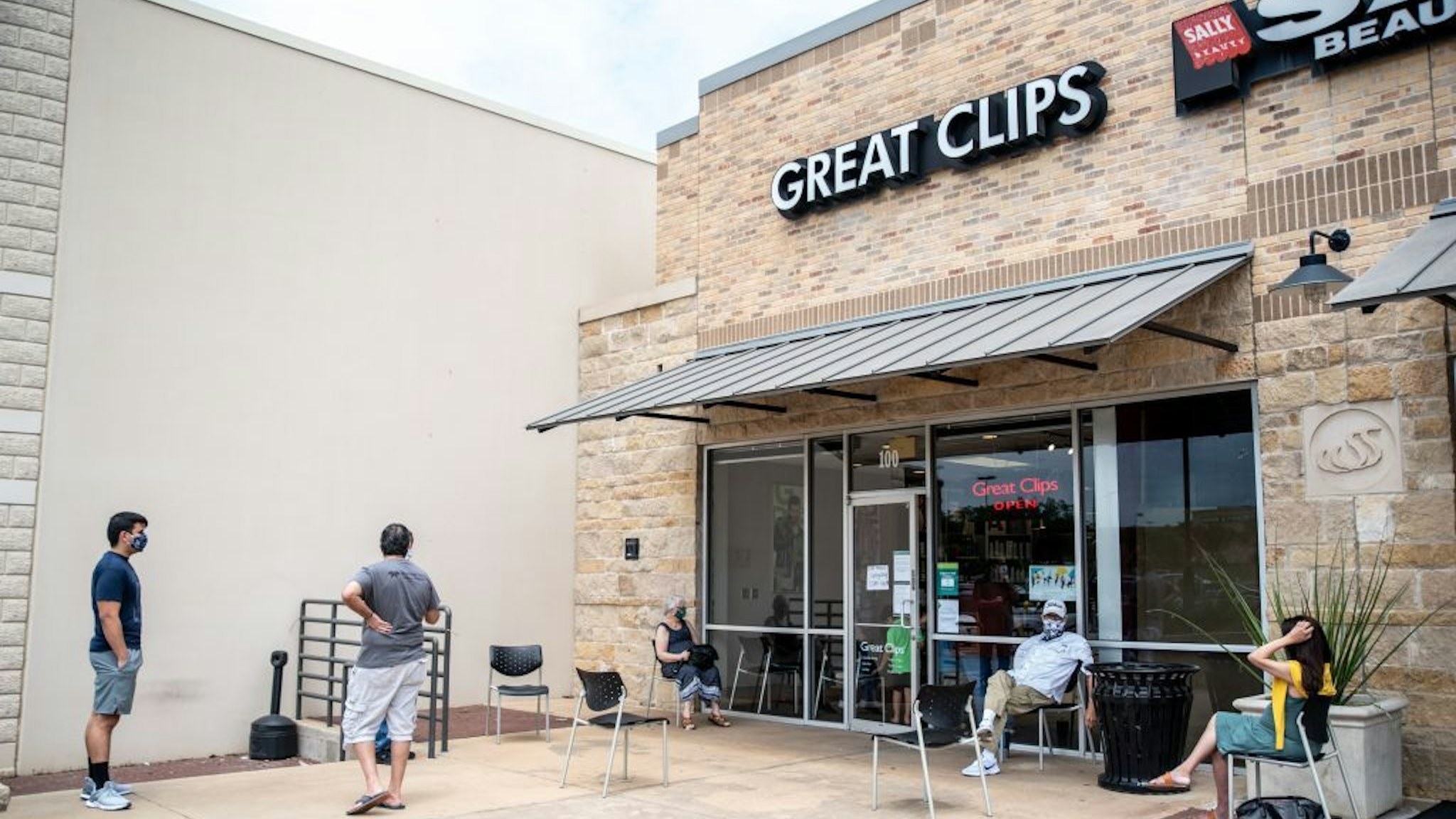 People wait for their haircuts outside Great Clips amid the coronavirus pandemic in Round Rock, Texas on May 8, 2020 following a slow reopening of the Texas economy. - A Texas hairdresser was sentenced to seven days in jail for keeping her salon open in violation of lockdown orders to slow the spread of the coronavirus, a move that state legislators decried on May 6, 2020 as "outrageous." (Photo by Sergio FLORES / AFP) (Photo by SERGIO FLORES/AFP via Getty Images)