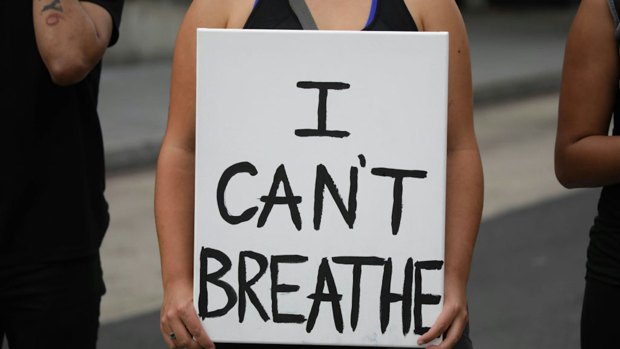 WASHINGTON, USA - MAY 29: A person holds a banner reading "I Can't Breathe", as crowds gather to protest after the death of George Floyd in Washington D.C. United States on May 29, 2020. Floyd, 46, a black man, was arrested Monday after reportedly attempting to use a counterfeit $20 bill at a local store. Video footage on Facebook showed him handcuffed and cooperating. But police claimed he resisted arrest. A white officer kneeled on his neck, despite Floyd√¢s repeated pleas of "I can't breathe." Former police officer Derek Chauvin was charged with third-degree murder and manslaughter, according to Hennepin County Prosecutor Michael Freeman. Minneapolis, Minnesota Mayor Jacob Frey said Friday he imposed a mandatory curfew because of ongoing protests regarding the death of George Floyd.