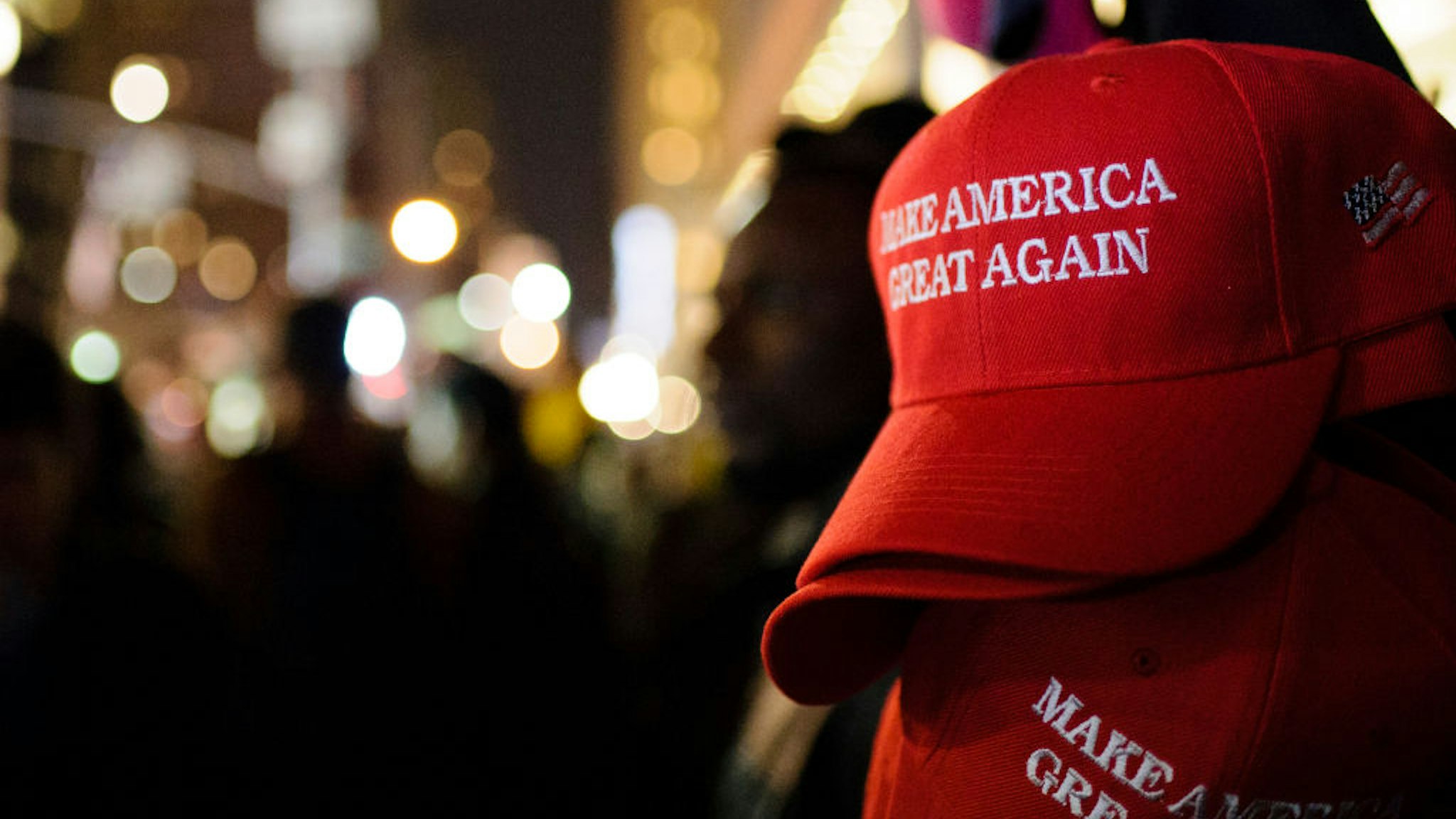 MANHATTAN, NEW YORK CITY, NEW YORK, UNITED STATES - 2016/11/09: "Make America Great Again" red baseball caps, signature headwear of the Donald Trump campaign and its supporters, stand on sale on 6th Avenue in Midtown Manhattan in the second hour after Election Day as election results point to a shock Trump win.
