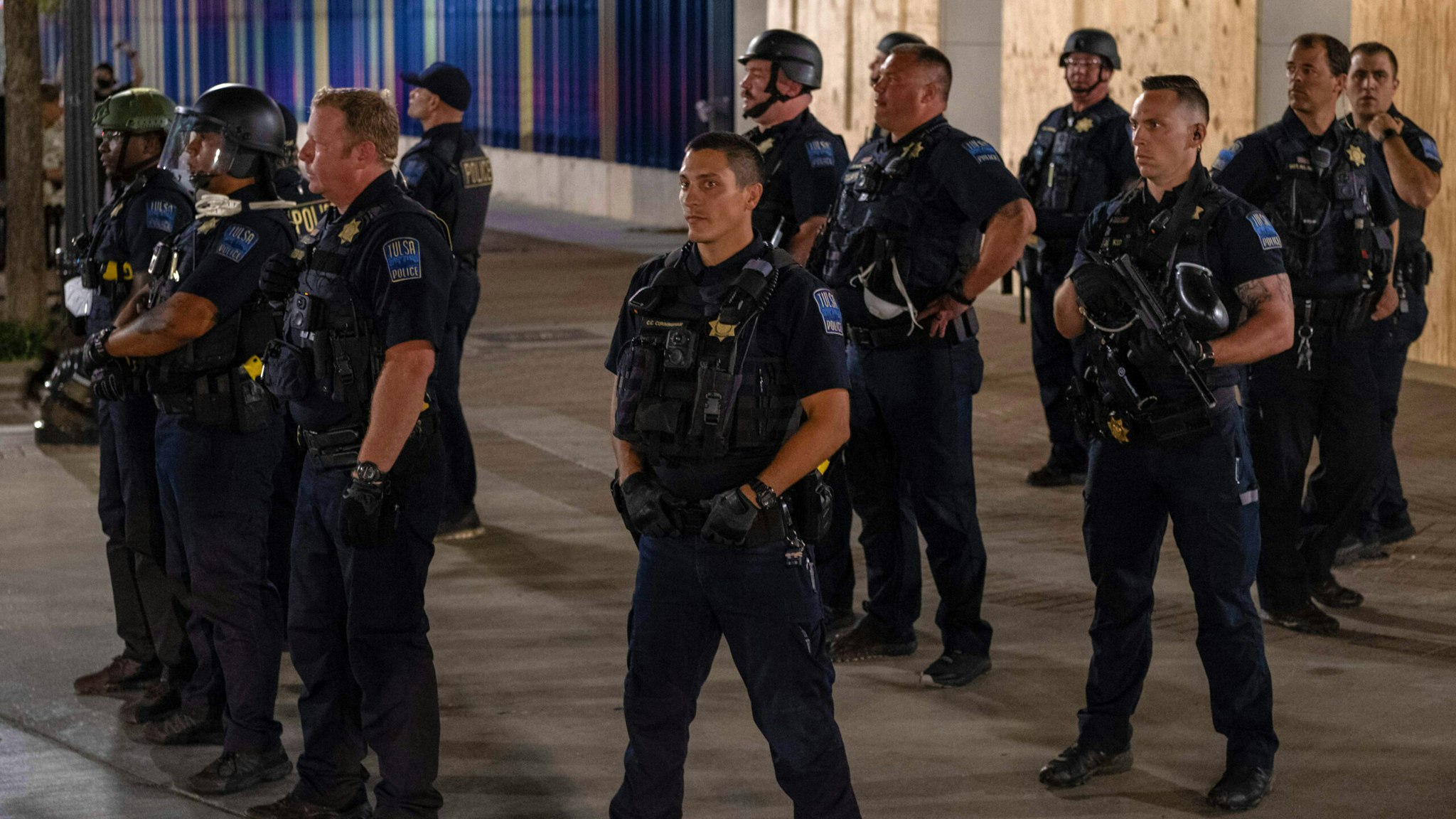 Tulsa Police Department officers stand in formation after leaving the area after shooting pepper balls at protesters as they marched and protested near the BOK Center in Tulsa, Oklahoma on June 20,2020 - Hundreds of supporters lined up early for Donald Trump's first political rally in months, saying the risk of contracting COVID-19 in a big, packed arena would not keep them from hearing the president's campaign message.