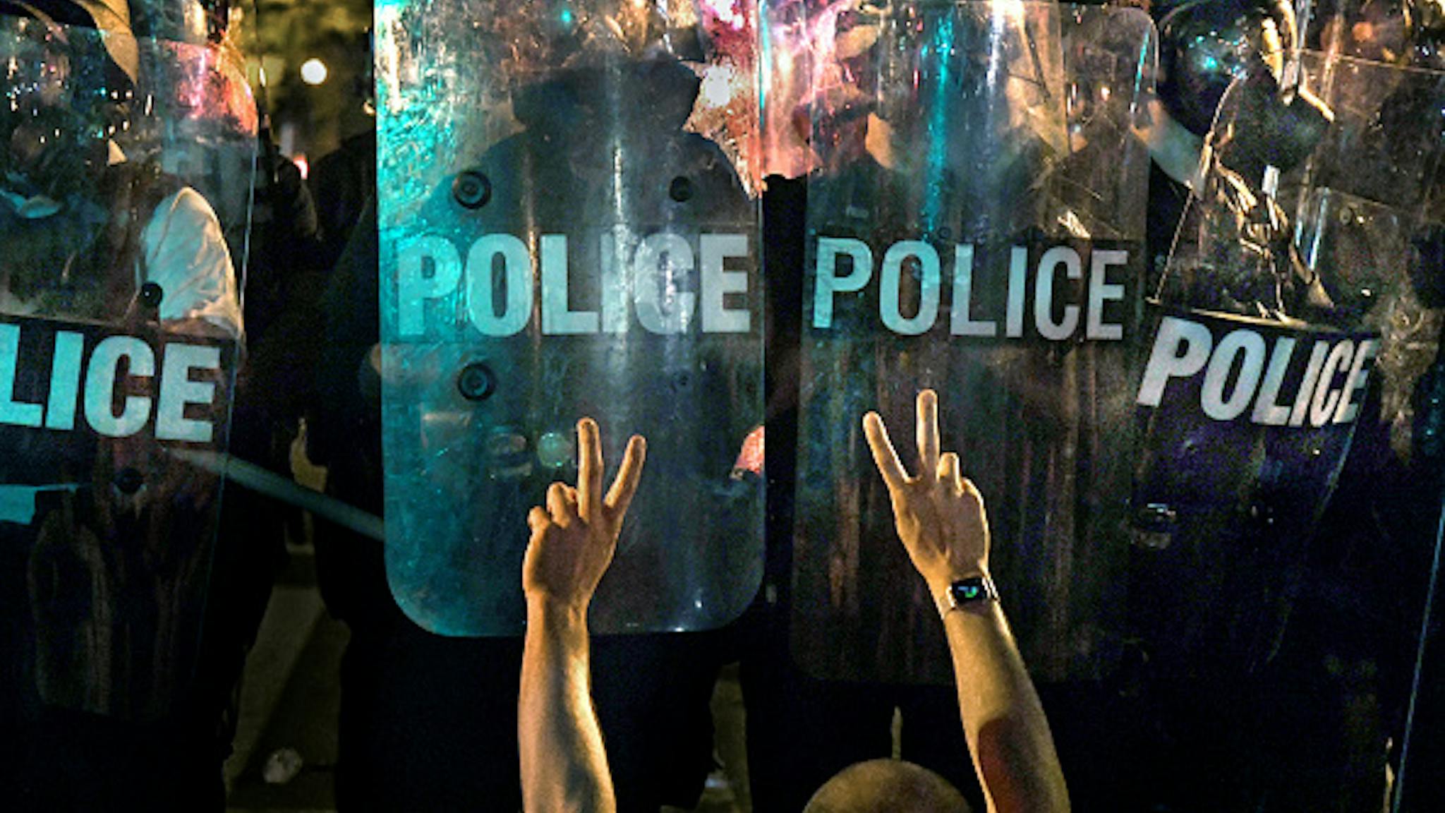 Anti-Trump Rally Near the White House Extends Into Overnight WASHINGTON, DC- MAY 31: A large group of protestors lingered late at the perimeter (the square itself was closed off) of Lafayette Square to protest racism and President Trump in Washington, D.C. in the early morning hours of May 31, 2020. One man, on his knees, flashed peace signs as he got close to the line of police officers. They were confronted by police officers who at various times fired tear gas, pepper spay pellets and used concussion grenades to control them.