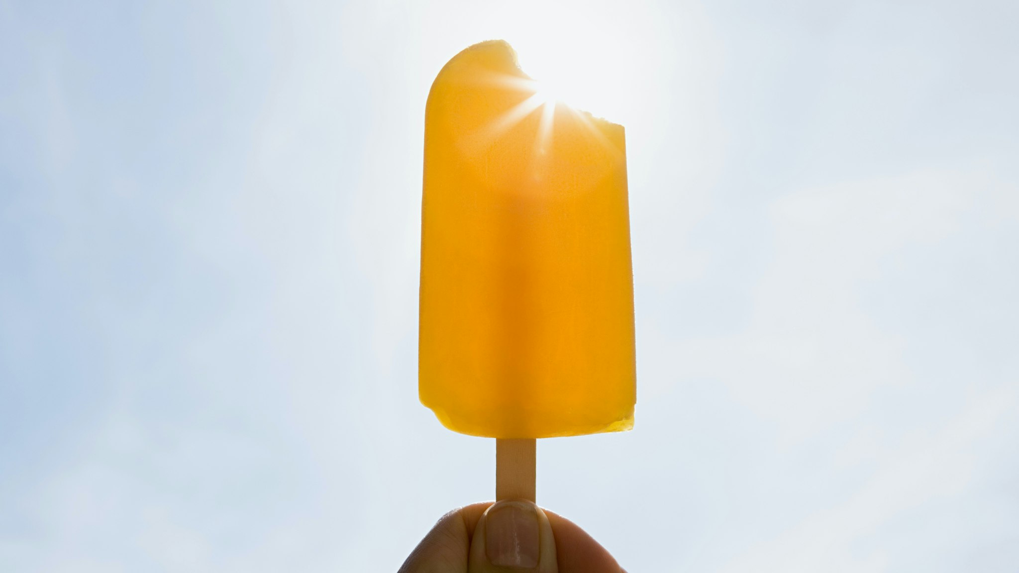 Person holding an ice lolly on a sunny day