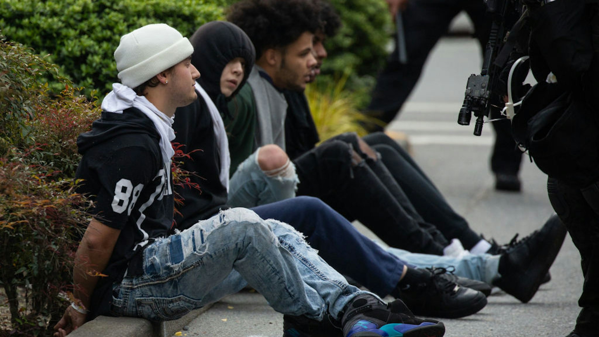 BELLEVUE, WA - MAY 31: Police detain people near Bellevue Square Mall on May 31, 2020 in Bellevue, Washington. Protests due to the recent death of George Floyd took place in Bellevue in addition to Seattle, with looting in Bellevue and at least one burned automobile there. (Photo by David Ryder/Getty Images)