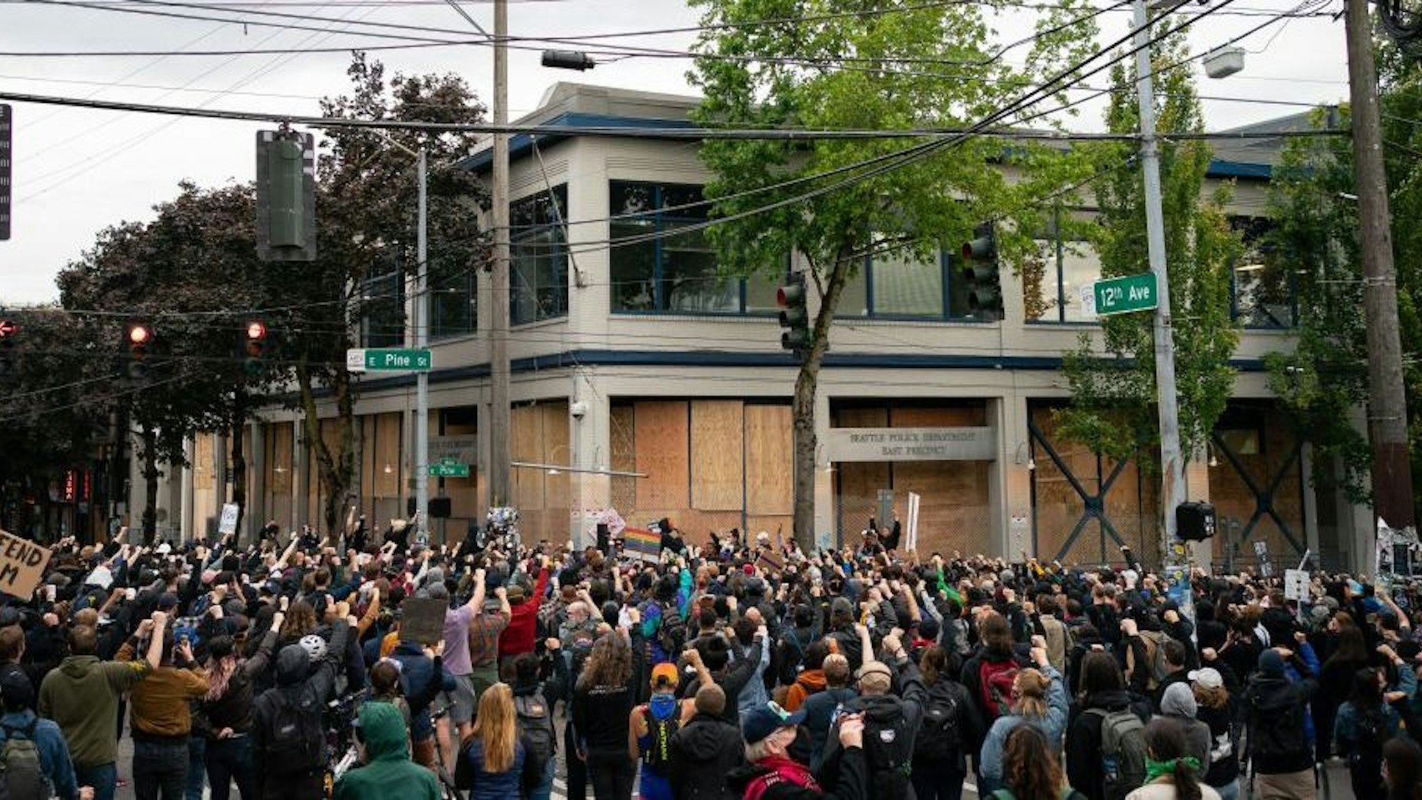 Demonstrators hold a rally and teach-in outside of the Seattle Police Department's East Precinct, which has been boarded up and protected by fencing, on June 8, 2020 in Seattle, Washington. Seattle Police and Washington National Guard personnel vacated the area after the previous night saw violent clashes in the vicinity during ongoing Black Lives Matter protests in the wake of George Floyds death. (Photo by David Ryder/Getty Images)