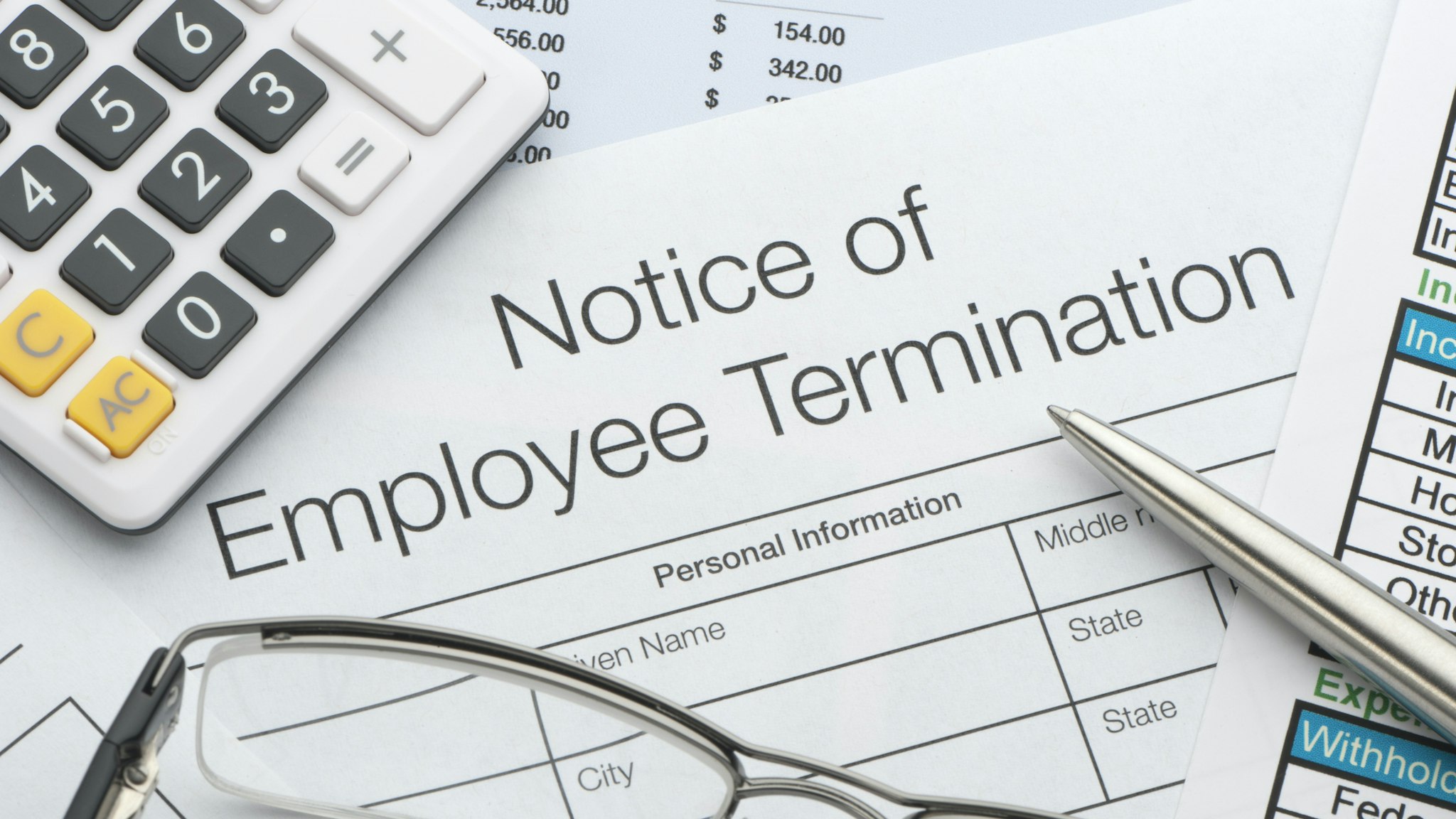 Close up of Employee termination form with pen and calculator