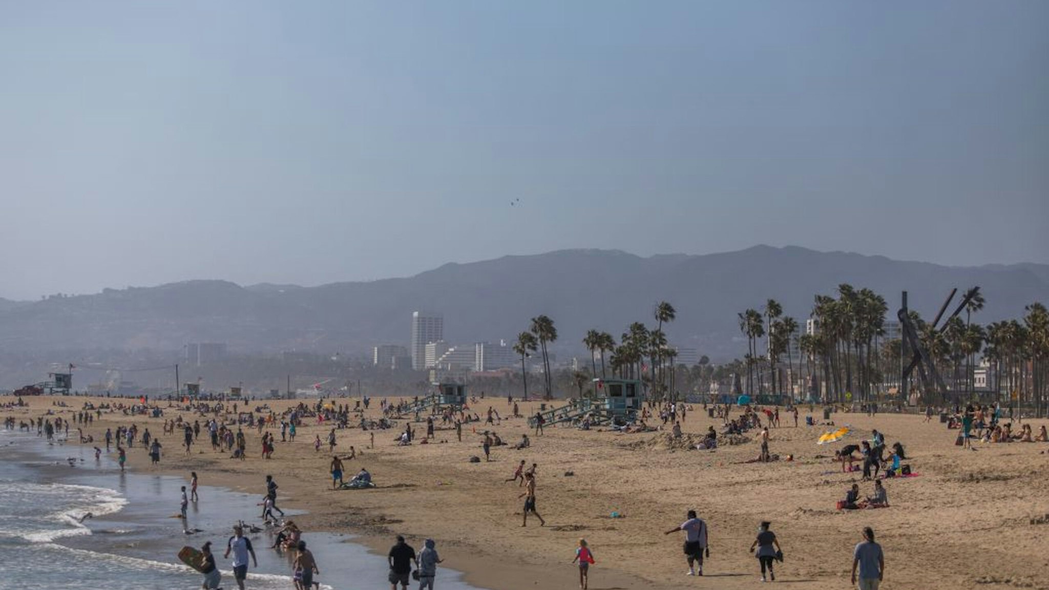 People enjoy Venice Beach during the first day of the Memorial Day holiday weekend during the novel Coronavirus, COVID-19, pandemic in California on May 23, 2020. - Los Angeles County officials announced May 22, 2020, that beach bike paths and some beach parking lots will reopen and curbside service at indoor malls will be permitted. The county reopened its beaches a week ago but kept beach parking lots, bike paths, piers and boardwalks closed. (Photo by Apu GOMES / AFP)