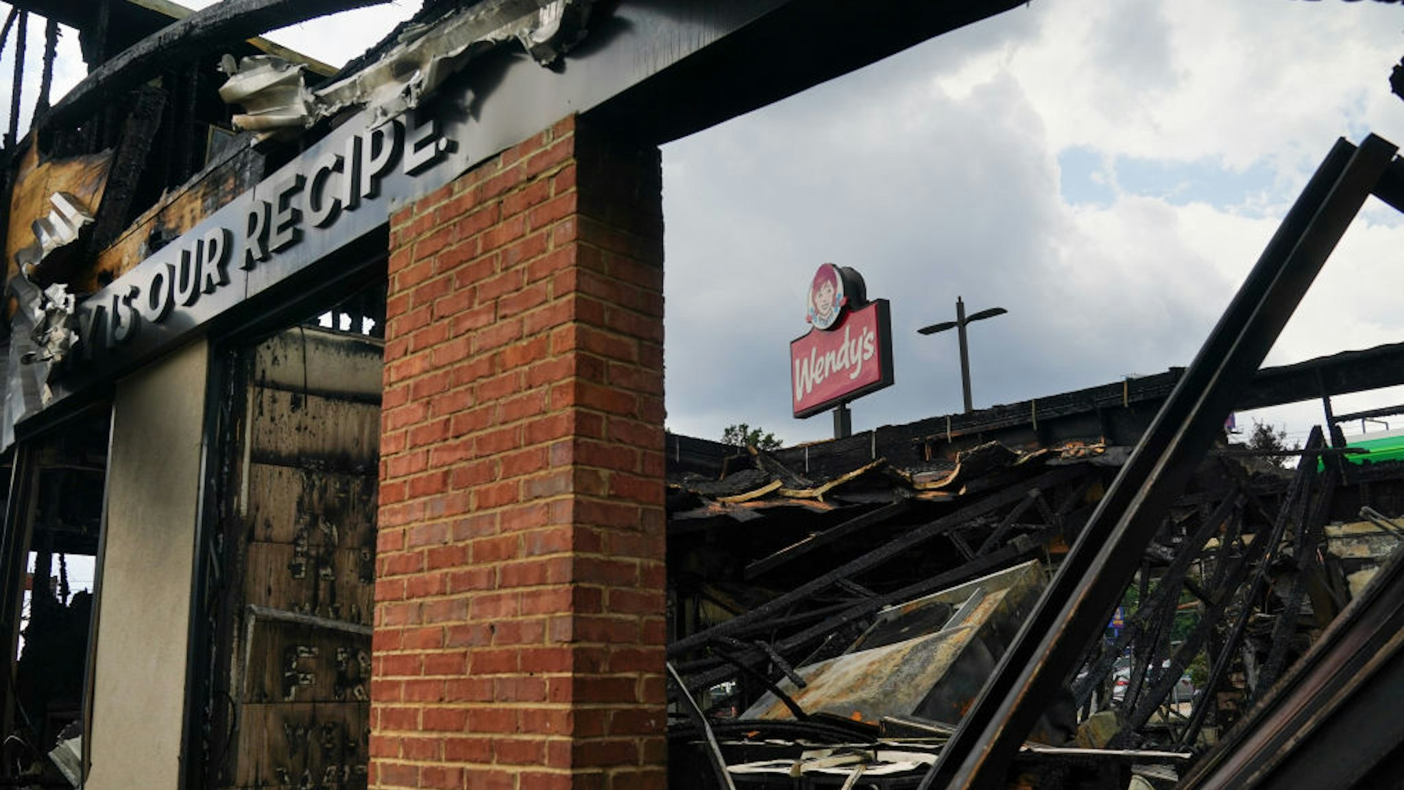 A burned Wendys restaurant is seen on the second day following the police shooting death of Rayshard Brooks in the restaurant parking lot June 14, 2020, in Atlanta, Georgia. - The fatal shooting of a black man by a white police officer, this time in Atlanta, Georgia, poured more fuel June 14, 2020 on a raging US debate over racism after another round of street protests and the resignation of the city's police chief. A Wendy's restaurant where 27-year-old Rayshard Brooks was killed was set on fire June 13, 2020 and hundreds of people marched to protest the killing. (Photo by Elijah Nouvelage / AFP) (Photo by ELIJAH NOUVELAGE/AFP via Getty Images)
