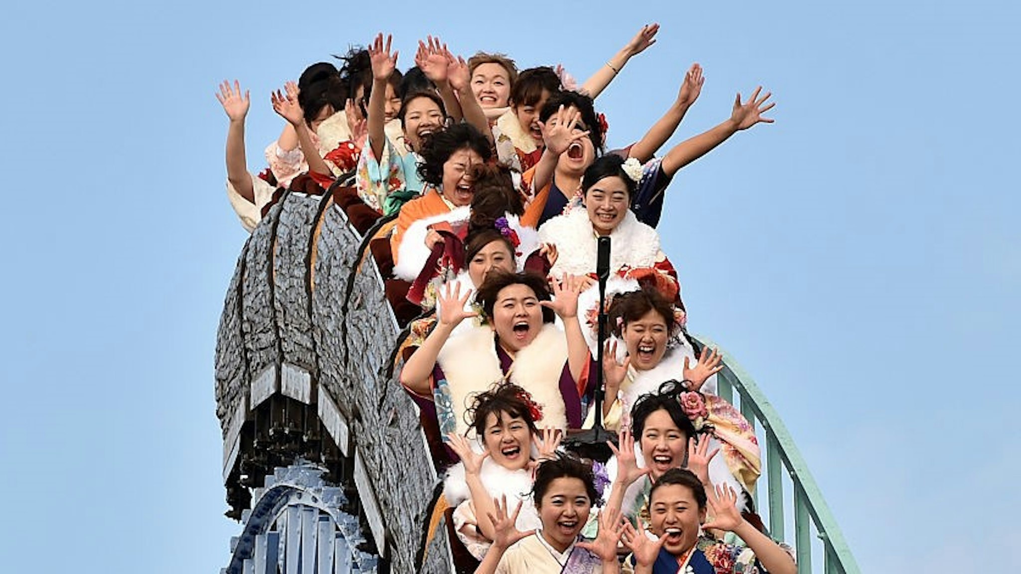 Twenty-year-old women wearing kimonos ride a rollercoaster after attending a "Coming-of-Age Day" celebration at the Toshimaen amusement park in Tokyo on January 11, 2016. The number of people celebrating "Coming-of-Age Day" in 2016, or adulthood - high by world standards at age 20 - is estimated to stand at 1.21 million, a decrease of 50,000 from the previous year. Every January, Japanese turning 20 celebrate Coming of Age Day, in which the new adults dress in formal kimonos, pray at Shinto shrines and hear speeches from local officials on their new responsibilities. / AFP / KAZUHIRO NOGI (Photo credit should read