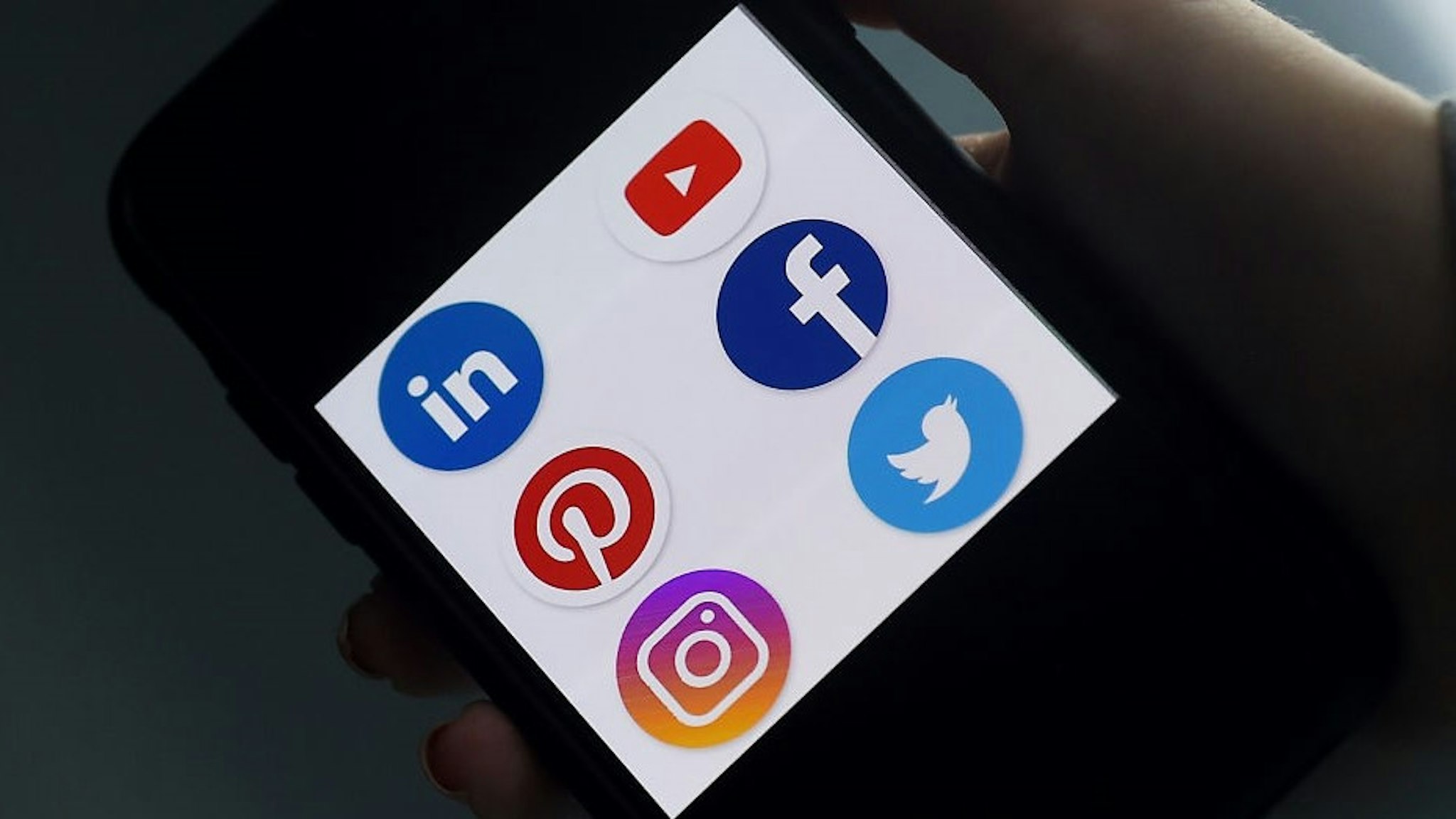 This illustration picture shows social media applications logos from Linkedin, YouTube, Pinterest, Facebook, Instagram and Twitter displayed on a smartphone in Arlington, Virginia on May 28, 2020. - Trump is expected to sign an executive order on May 28, 2020, after threatening to shutter social media platforms following Twitter's move to label two of his tweets misleading. (Photo by Olivier DOULIERY / AFP) (Photo by