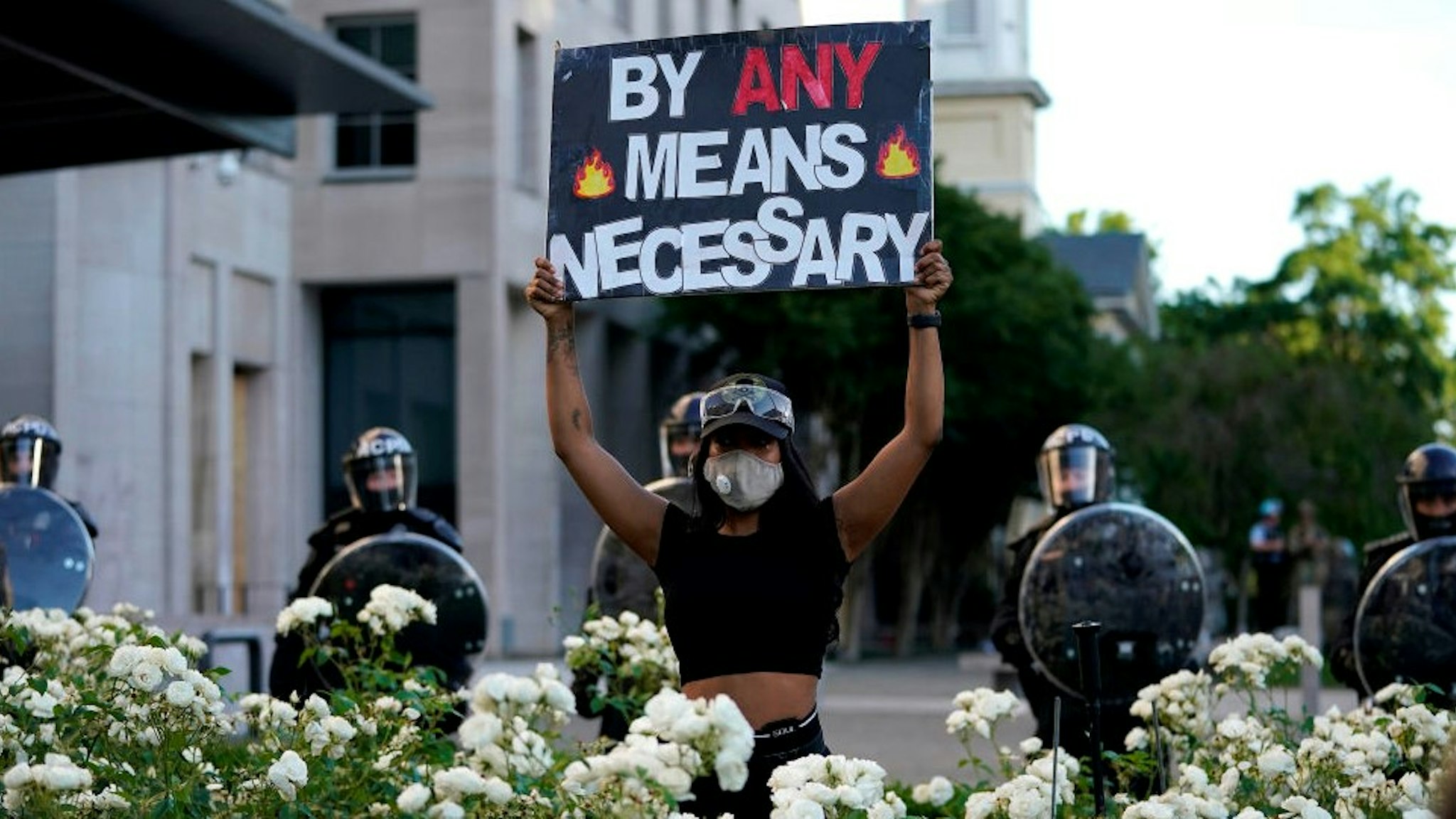 WASHINGTON, DC - JUNE 01: A demonstrator holds up a sign in front of a police line during protest on June 1, 2020 in downtown Washington, DC. Protests and riots continue in cities across America following the death of George Floyd, who died after being restrained by Minneapolis police officer Derek Chauvin. Chauvin, 44, was charged last Friday with third-degree murder and second-degree manslaughter. (Photo by