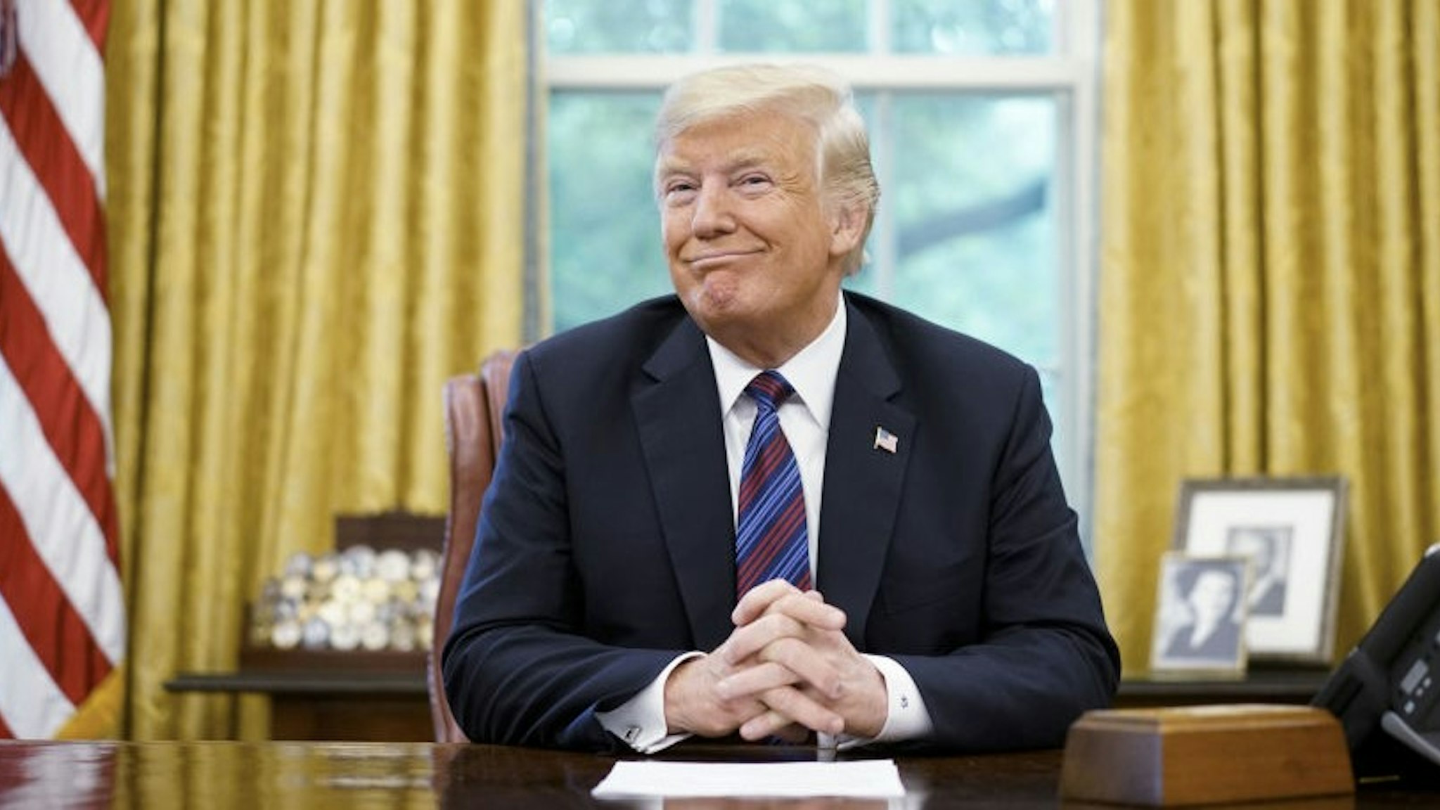 US President Donald Trump smiles during a phone conversation with Mexico's President Enrique Pena Nieto on trade in the Oval Office of the White House in Washington, DC on August 27, 2018. - President Donald Trump said Monday the US had reached a "really good deal" with Mexico and talks with Canada would begin shortly on a new regional free trade pact."It's a big day for trade. It's a really good deal for both countries," Trump said."Canada, we will start negotiations shortly. I'll be calling their prime minister very soon," Trump said.US and Mexican negotiators have been working for weeks to iron out differences in order to revise the nearly 25-year old North American Free Trade Agreement, while Canada was waiting to rejoin the negotiations. (Photo by MANDEL NGAN / AFP) (Photo by