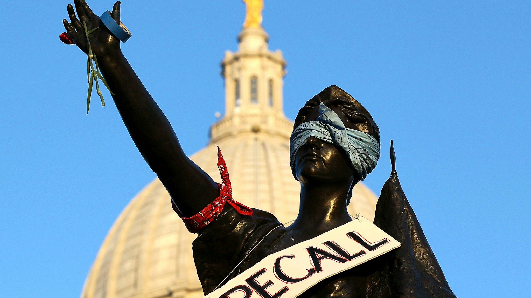 MADISON, WI - MARCH 10: A sign to recall Wisconsin Governor Scott Walker hangs on a statue in front of the Wisconsin State Capitol on March 10, 2011 in Madison, Wisconsin. Thousands of demonstrators continue to protest at the Wisconsin State Capitol as the Wisconsin House voted to pass the state's controversial budget bill one day after Wisconsin Republican Senators voted to curb collective bargaining rights for public union workers in a surprise vote with no Democrats present.
