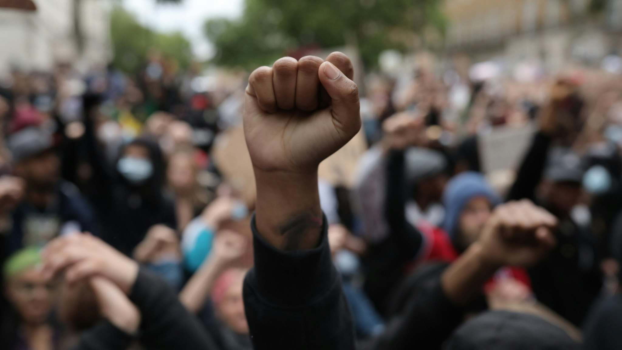Protesters raise clenched fists during a Black Lives Matter protest outside the Houses of Parliament on June 3, 2020 in London, United Kingdom.