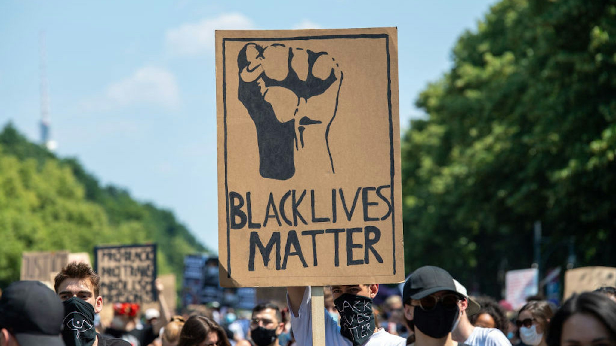27 June 2020, Berlin: During a "Black Lives Matter" demonstration at the Victory Column, a participant holds a poster with the words "Black Lives Matter". More than 1000 people demonstrated against racism on the Street of June 17. Photo: Christophe Gateau/dpa (Photo by Christophe Gateau/picture alliance via Getty Images)