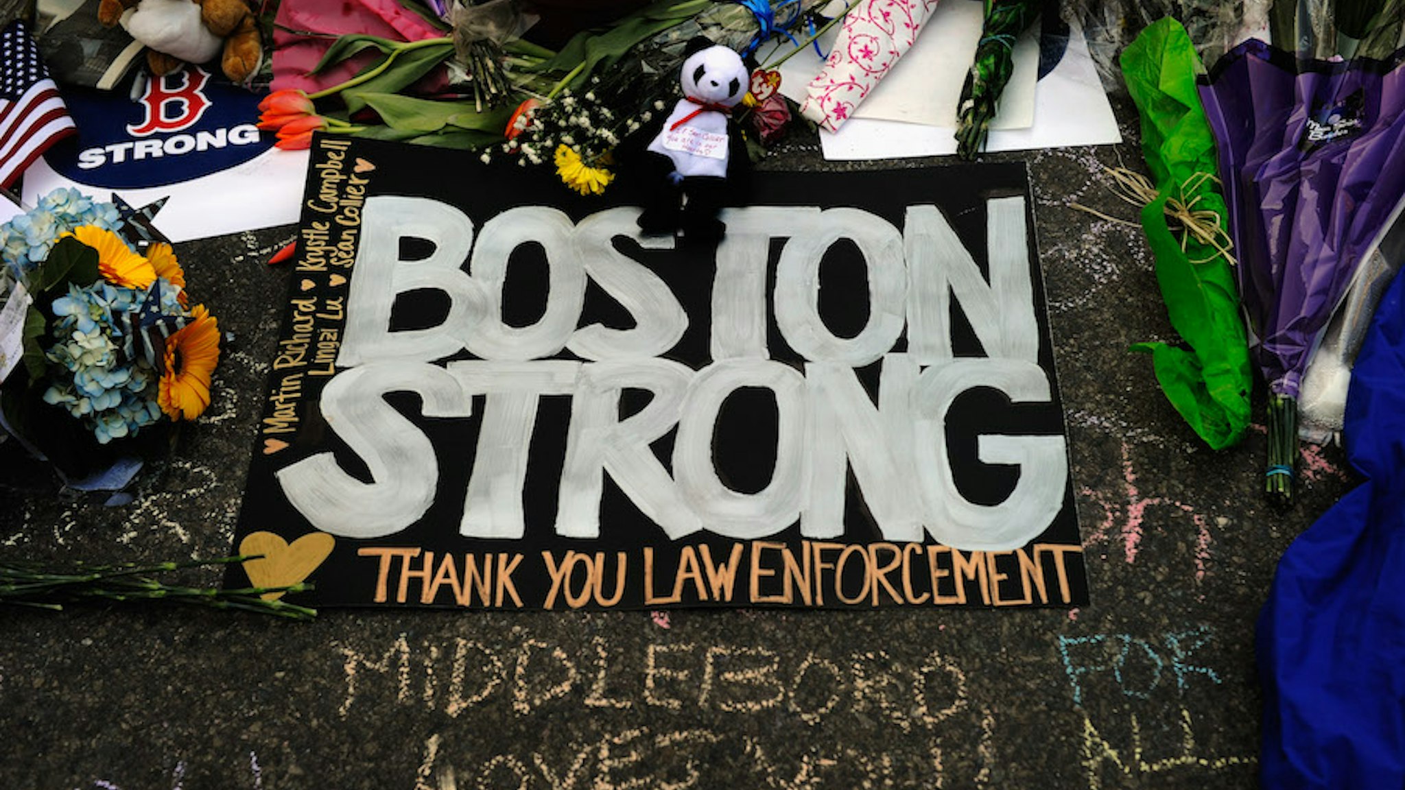BOSTON, MA - APRIL 21: A large sign with the names of the Boston Marathon bombing victims and thanking law enforcement is placed by a Boston Bruins hockey team fan at a makeshift memorial for victims near the site of the bombings at the intersection of Boylston Street and Berkley Street two days after the second suspect was captured on April 21, 2013 in Boston,Massachusetts. A manhunt for Dzhokhar A. Tsarnaev, 19, a suspect in the Boston Marathon bombing ended after he was apprehended on a boat parked on a residential property in Watertown, Massachusetts. His brother Tamerlan Tsarnaev, 26, the other suspect, was shot and killed after a car chase and shootout with police. The bombing, on April 15 at the finish line of the marathon, killed three people and wounded at least 170. (Photo by Kevork Djansezian/Getty Images)