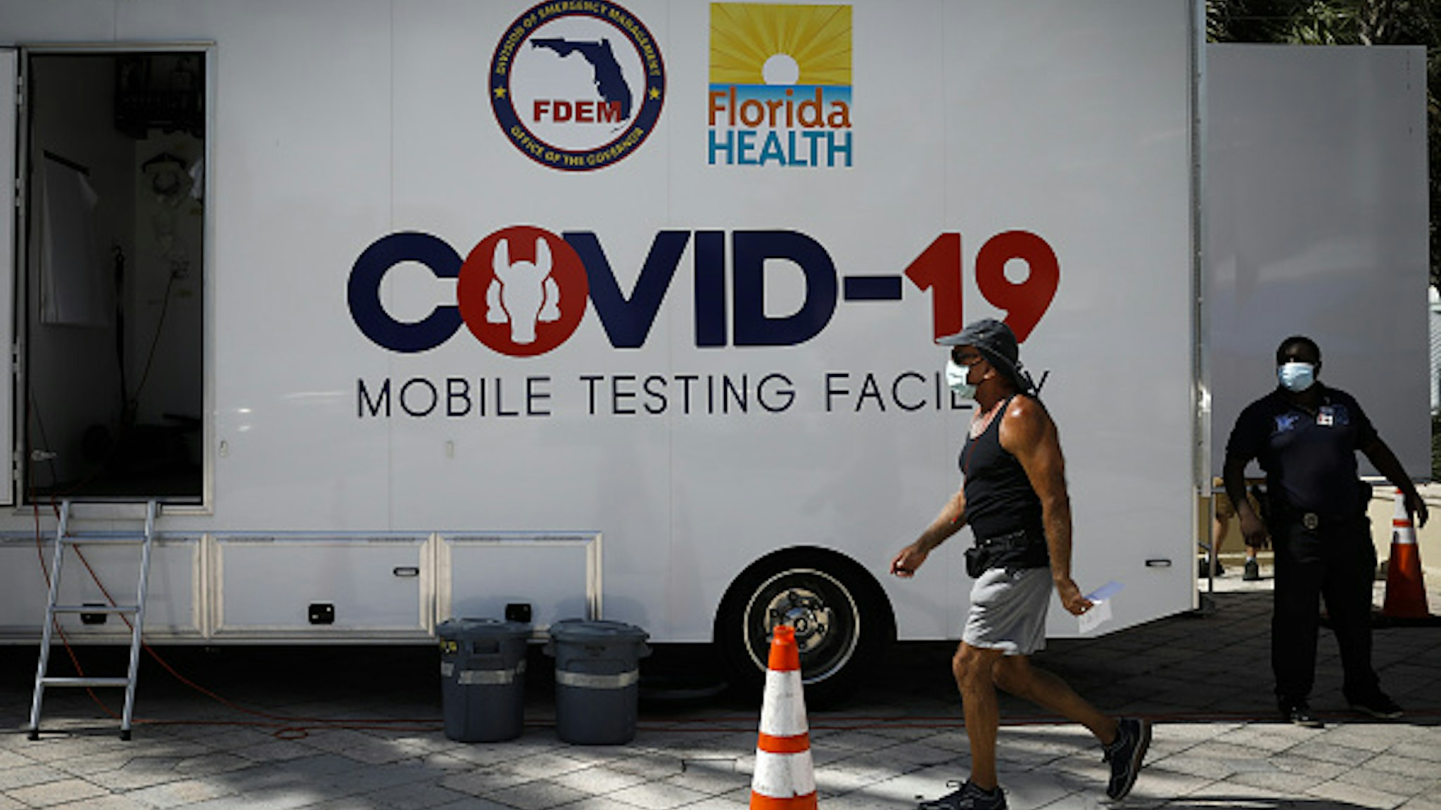 FLORIDA, USA - JULY 24: A man walks in front of a mobile COVID-19 testing facility, in Miami Beach, Florida, United States on July 24, 2020.