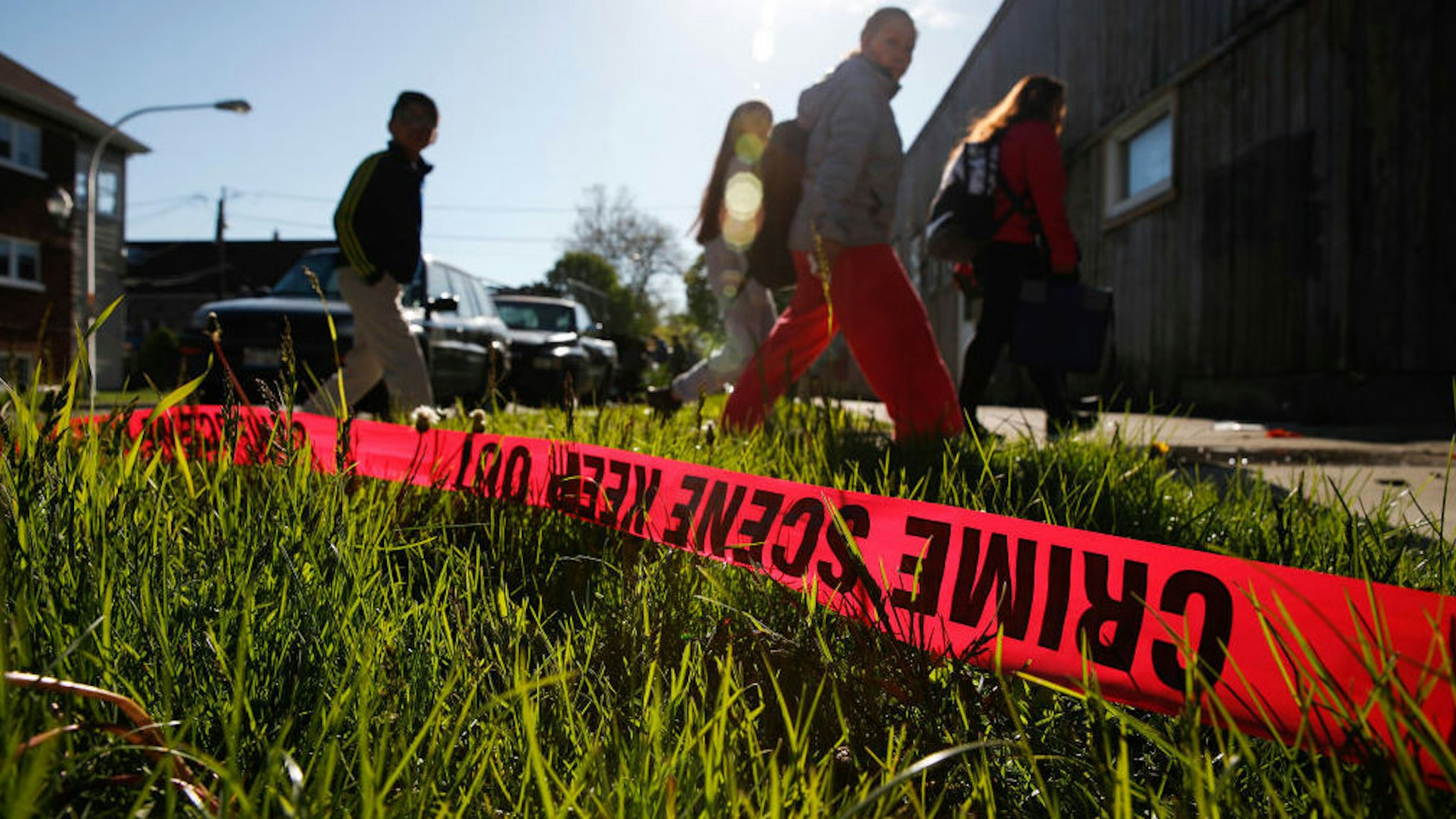 Pedestrians walk near the intersection of South Rockwell Street and West 46th Place in the Brighton Park of Chicago on Monday, May 8, 2017 where two people were killed and eight others were wounded in an attack at the site of a memorial for a man who was slain yesterday. Chicago police First Deputy Superintendent Kevin Navarro told reporters at the scene in the 2600 block of West 46th Place that the attack was "another brazen act of gang violence." (Jose M. Osorio/Chicago Tribune/TNS)