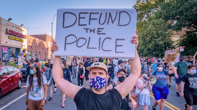 A counterprotester holding a Defund Police sign at the protest. Pro-NYPD marchers clashed with a big crowd of Black Lives Matter counterprotesters during the Ã¬Back the BlueÃ® rally and march in Bay Ridge, Brooklyn. (Photo by Erik McGregor/LightRocket via Getty Images)