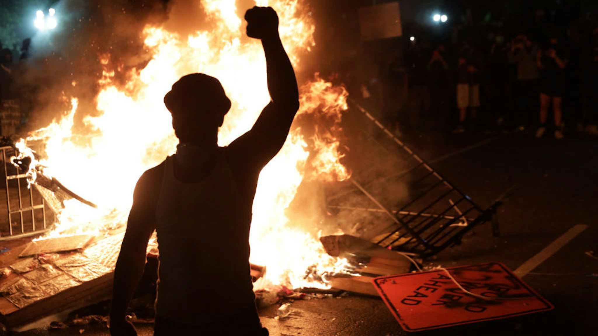 WASHINGTON, DC - MAY 31: Demonstrators stand around a fire during a protest near the White House in response to the killing of George Floyd May 31, 2020 in Washington, DC. Former Minneapolis police officer Derek Chauvin was fired then arrested for Floyd's death and is accused of killing Floyd by kneeling on his neck. Chauvin and three other officers, Tou Thao, J Alexander Kueng and Thomas K. Lane, were involved in Floyd's arrest on an accusation of "forgery-in-progress". (Photo by Alex Wong/Getty Images)