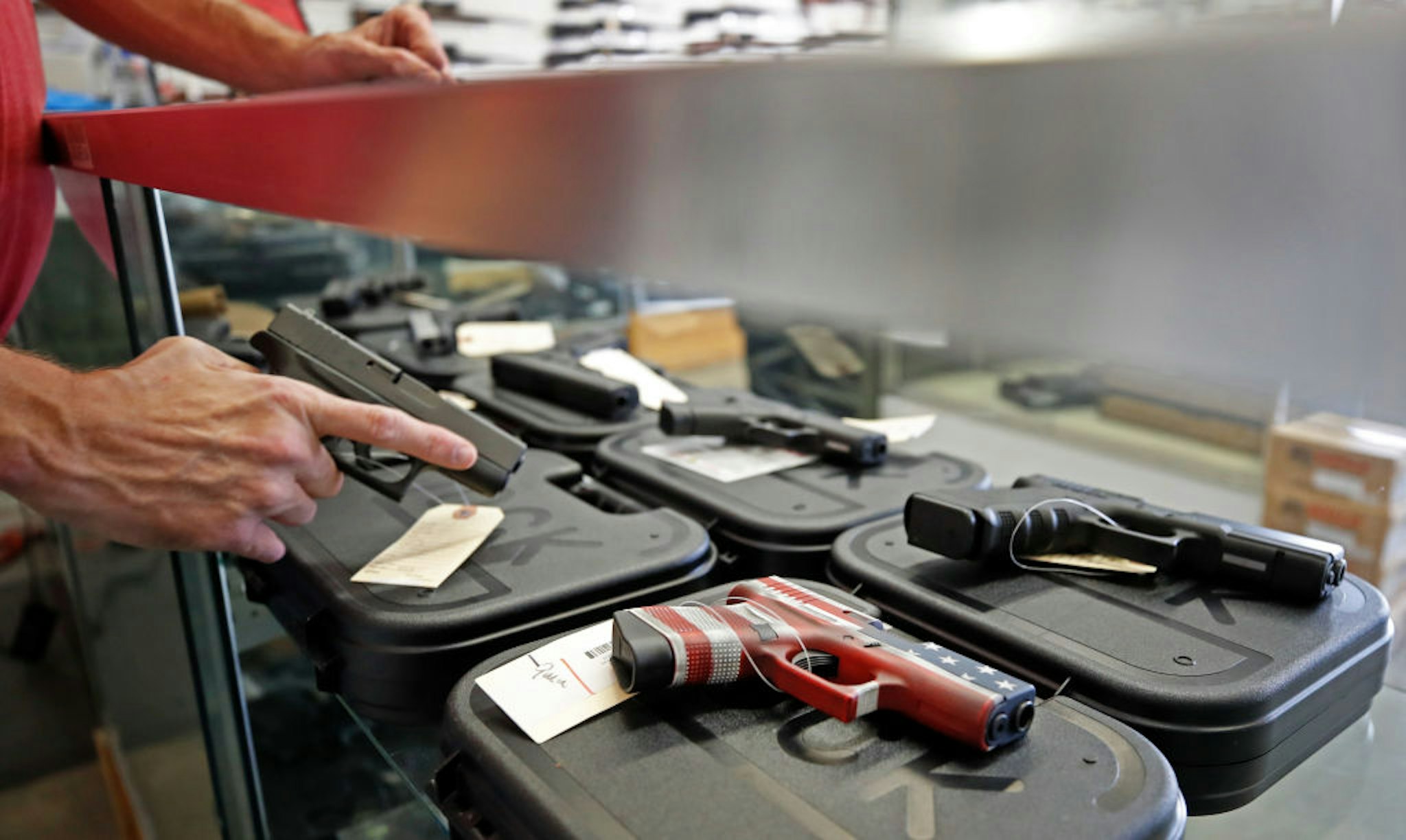 A worker restocks handguns at Davidson Defense in Orem, Utah on March 20, 2020.