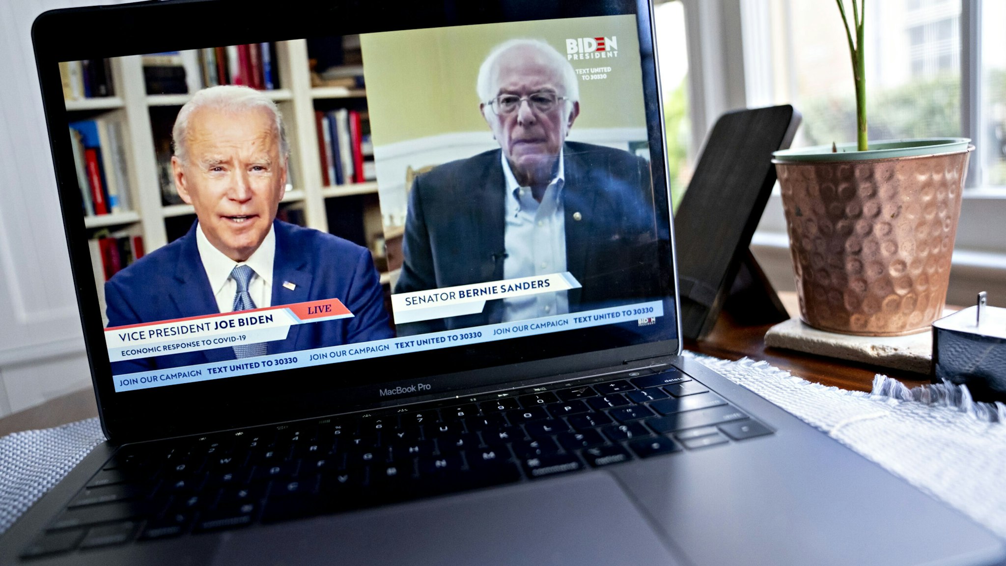 Former Vice President Joe Biden, presumptive Democratic presidential nominee, left, speaks as Senator Bernie Sanders, an Independent from Vermont, right, listens during a virtual event seen on an Apple Inc. laptop computer in Arlington, Virginia, U.S., on Monday, April 13, 2020. Sanders endorsed Biden during the joint livestream saying that Americans of all political affiliations should back the former vice president. Photographer: Andrew Harrer/Bloomberg via Getty Images