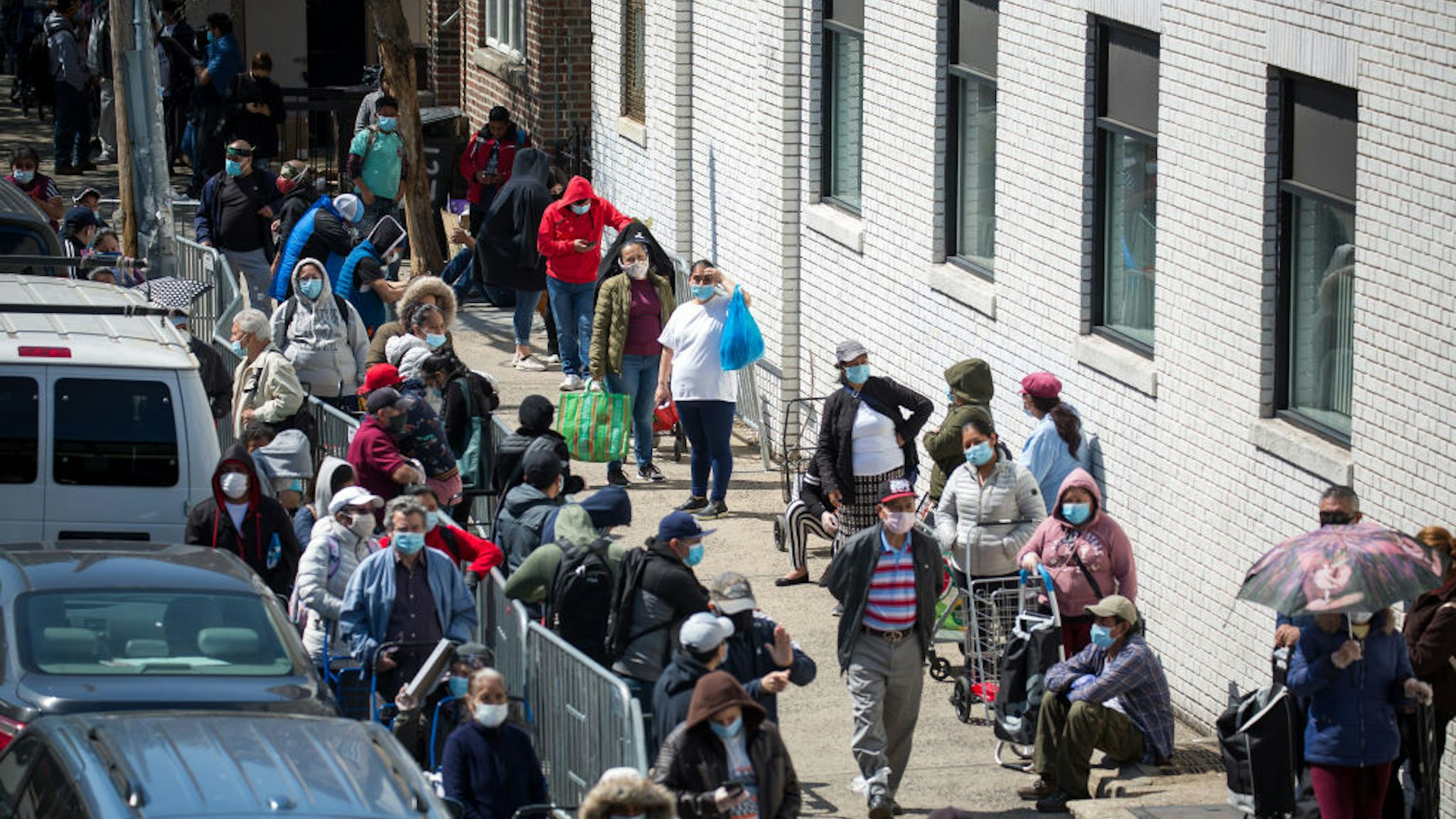 People wait to receive food at a food distribution site in the Brooklyn borough of New York, the United States, May 14, 2020.