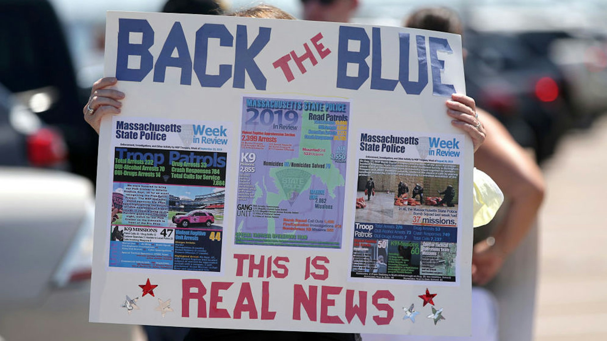 A sign posts "real news" and calls to "back the blue" at a Back the Blue rally in support of police departments on Quincy Shore Drive in Quincy, MA on June 20, 2020.