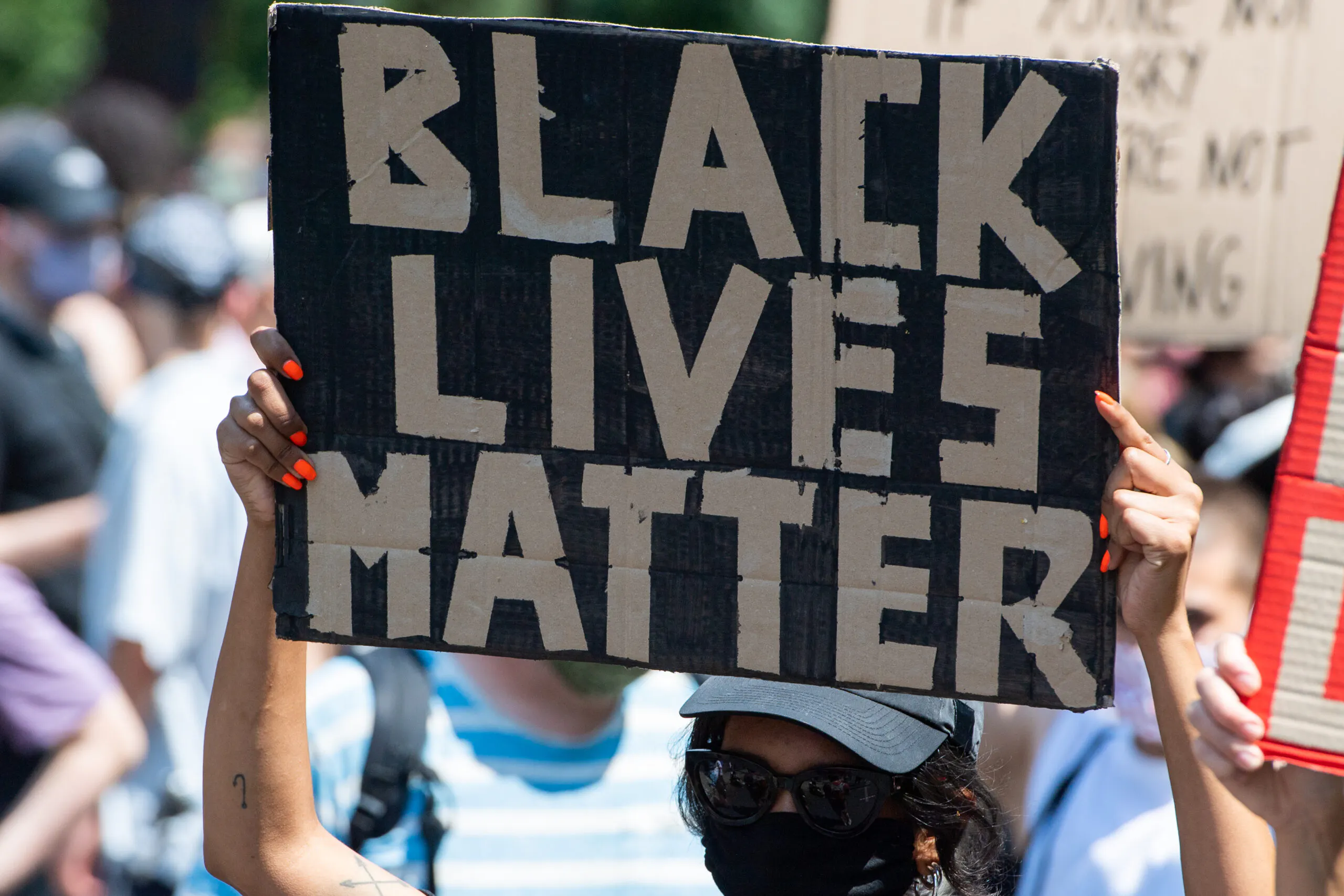 27 June 2020, Berlin: A participant of the "Black Lives Matter" demonstration holds a poster with the words "Black Lives Matter". More than 1000 people demonstrated against racism on the street of June 17. Photo: Christophe Gateau/dpa (Photo by Christophe Gateau/picture alliance via Getty Images)