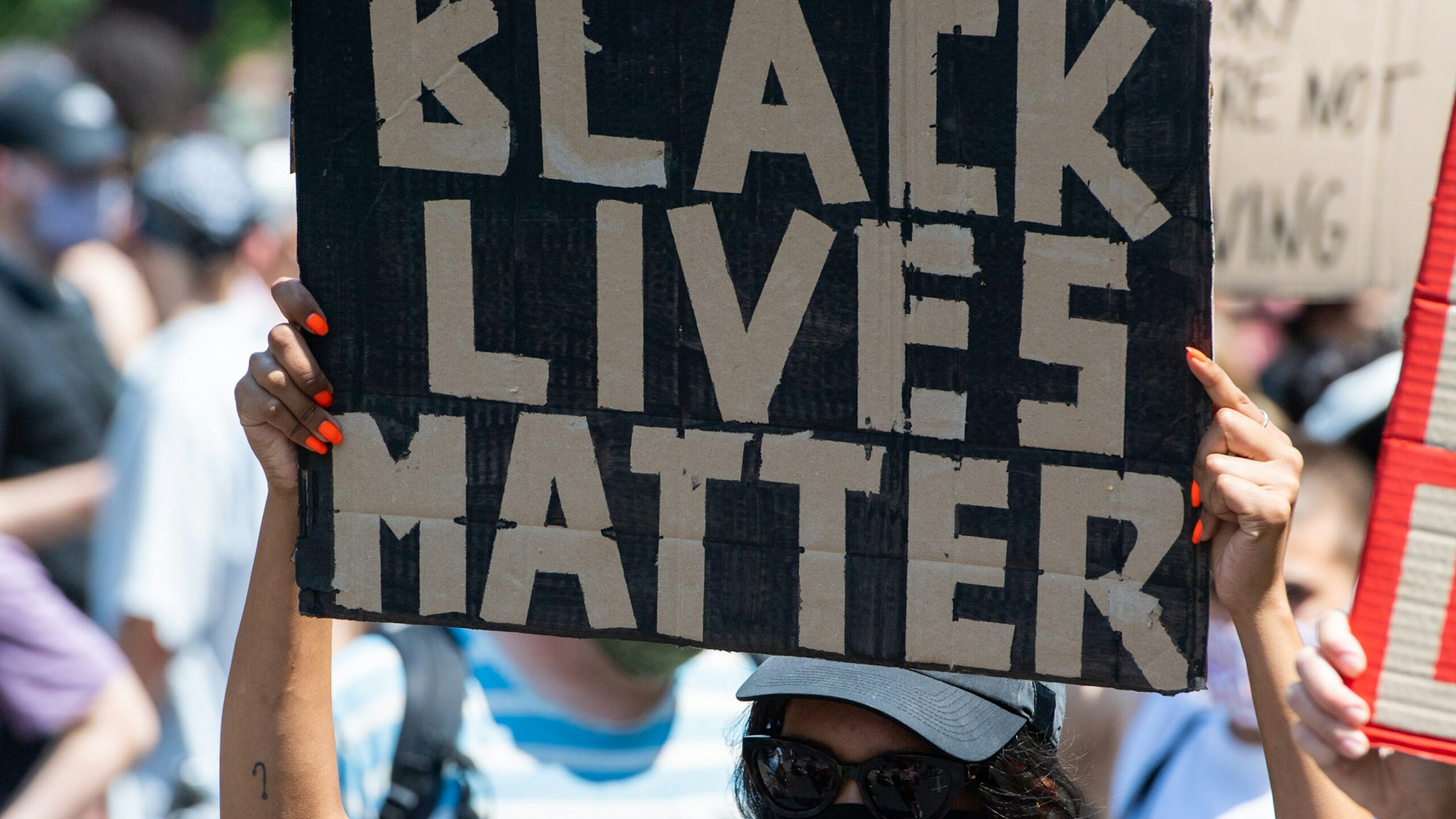 27 June 2020, Berlin: A participant of the "Black Lives Matter" demonstration holds a poster with the words "Black Lives Matter". More than 1000 people demonstrated against racism on the street of June 17. Photo: Christophe Gateau/dpa (Photo by Christophe Gateau/picture alliance via Getty Images)
