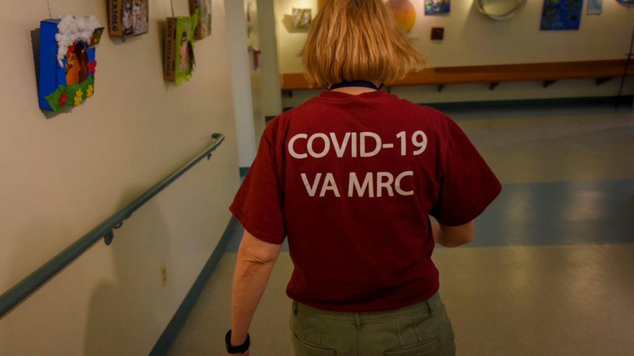 Seileen Mullen, with the Virginia medical reserve corps, passes through the halls where the Alexandria Health Department set up offices for coronavirus contact tracing and investigations at the Oswald Durant Arts Center in Alexandria, VA, on Wednesday, June 24, 2020.